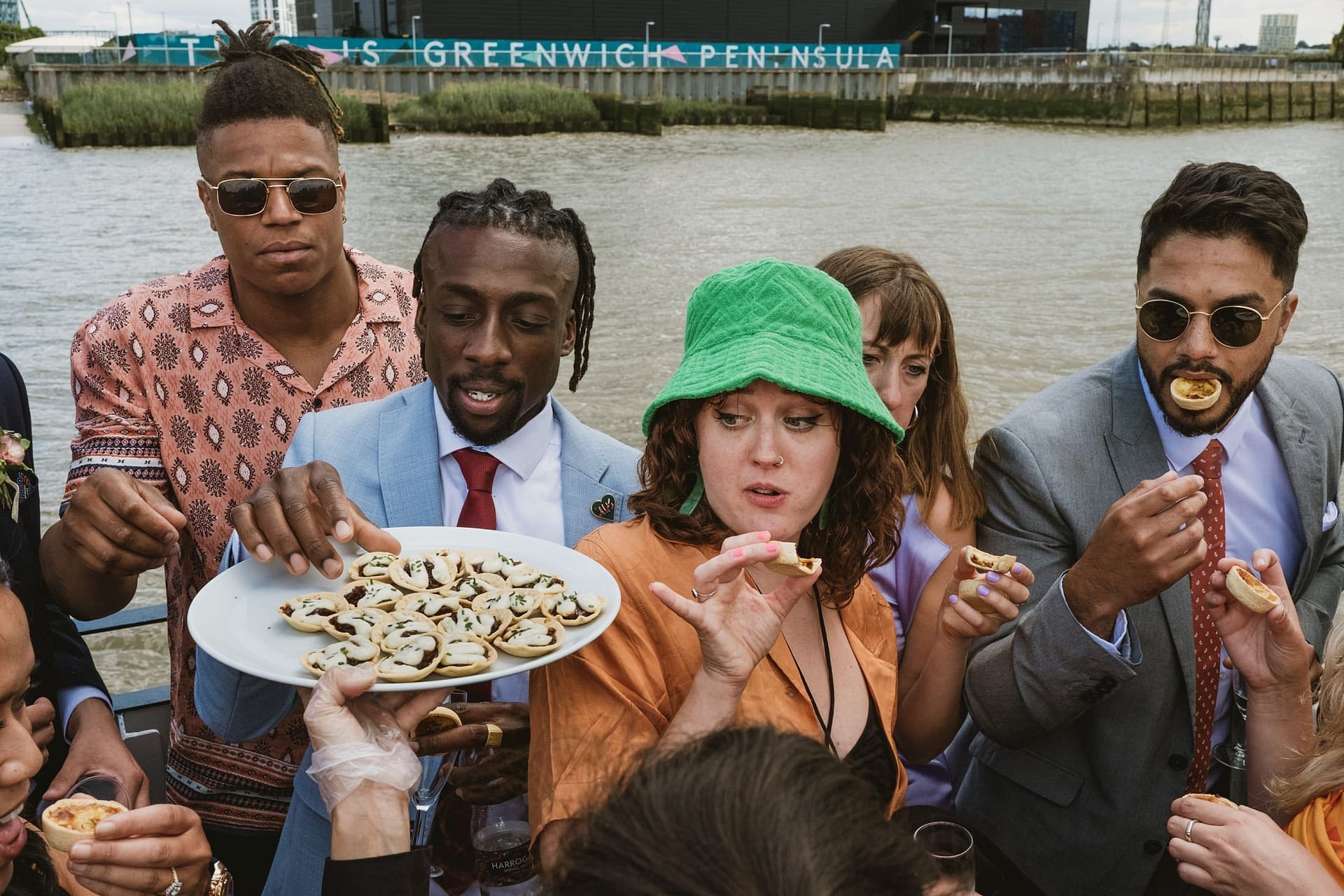 A group of people enjoying Greenwich Yacht Club Wedding Photography on a boat while eating food.