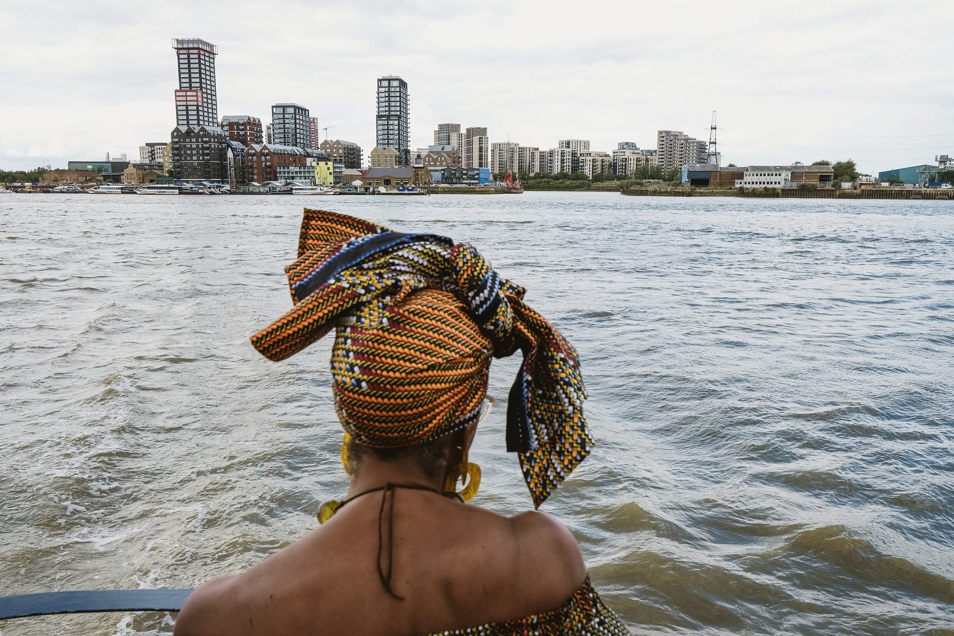 A woman on a boat enjoying the picturesque view of the city during her Greenwich Yacht Club wedding photography session.