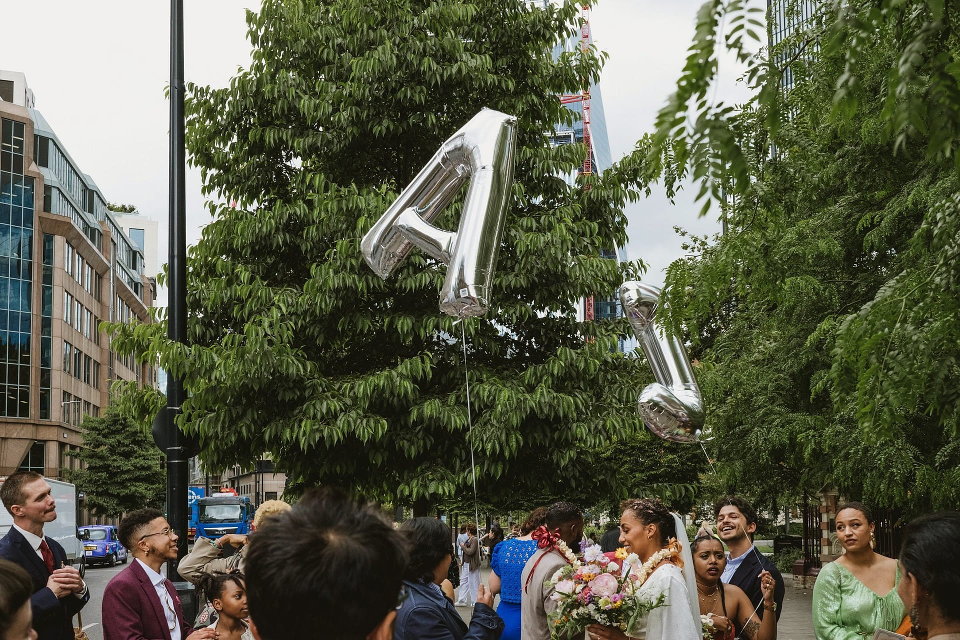 At the Greenwich Yacht Club Wedding, a group of people joyfully holds balloons in the air.