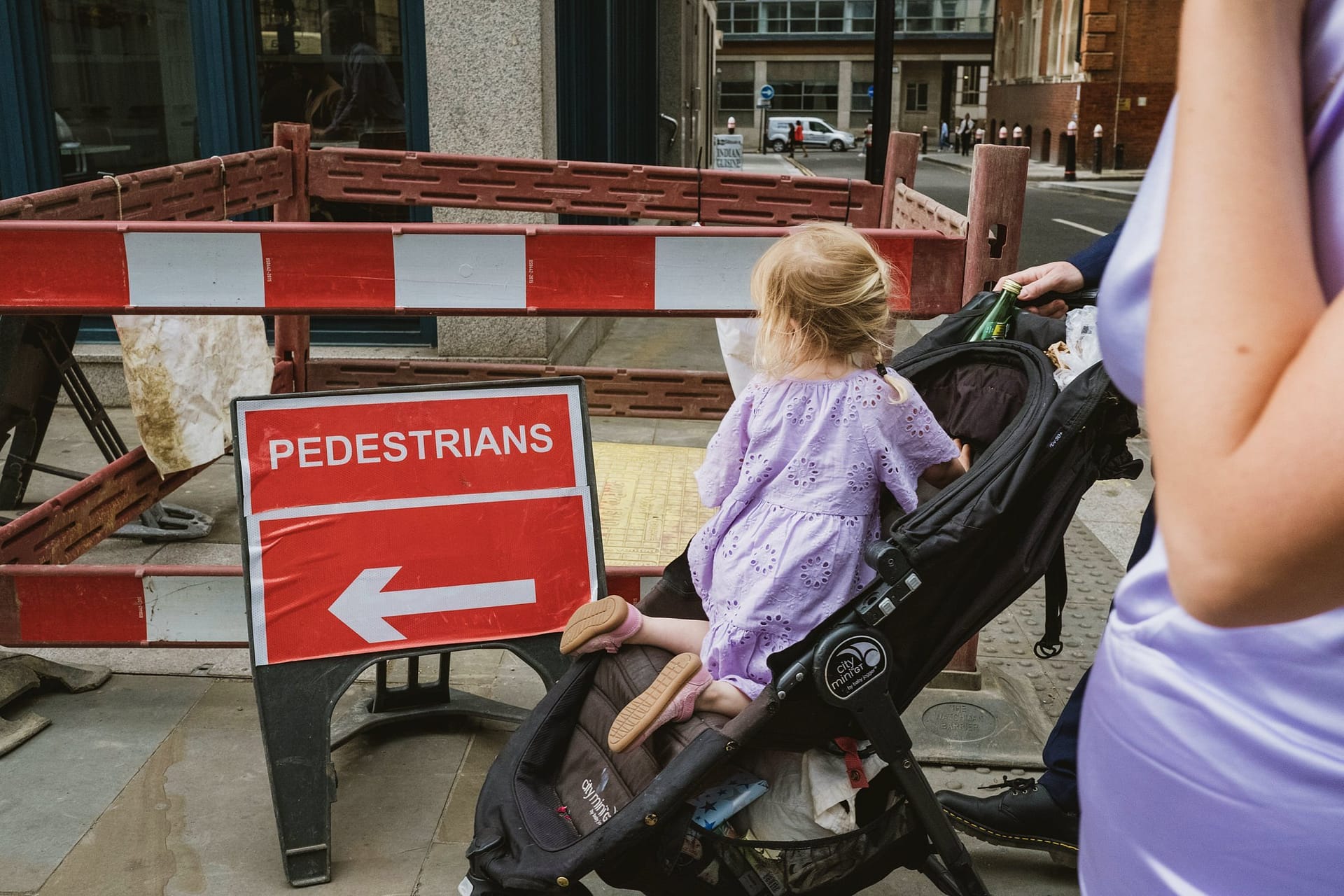 A woman with a baby in a stroller is seen near a pedestrian sign, capturing the essence of Greenwich Yacht Club Wedding Photography.