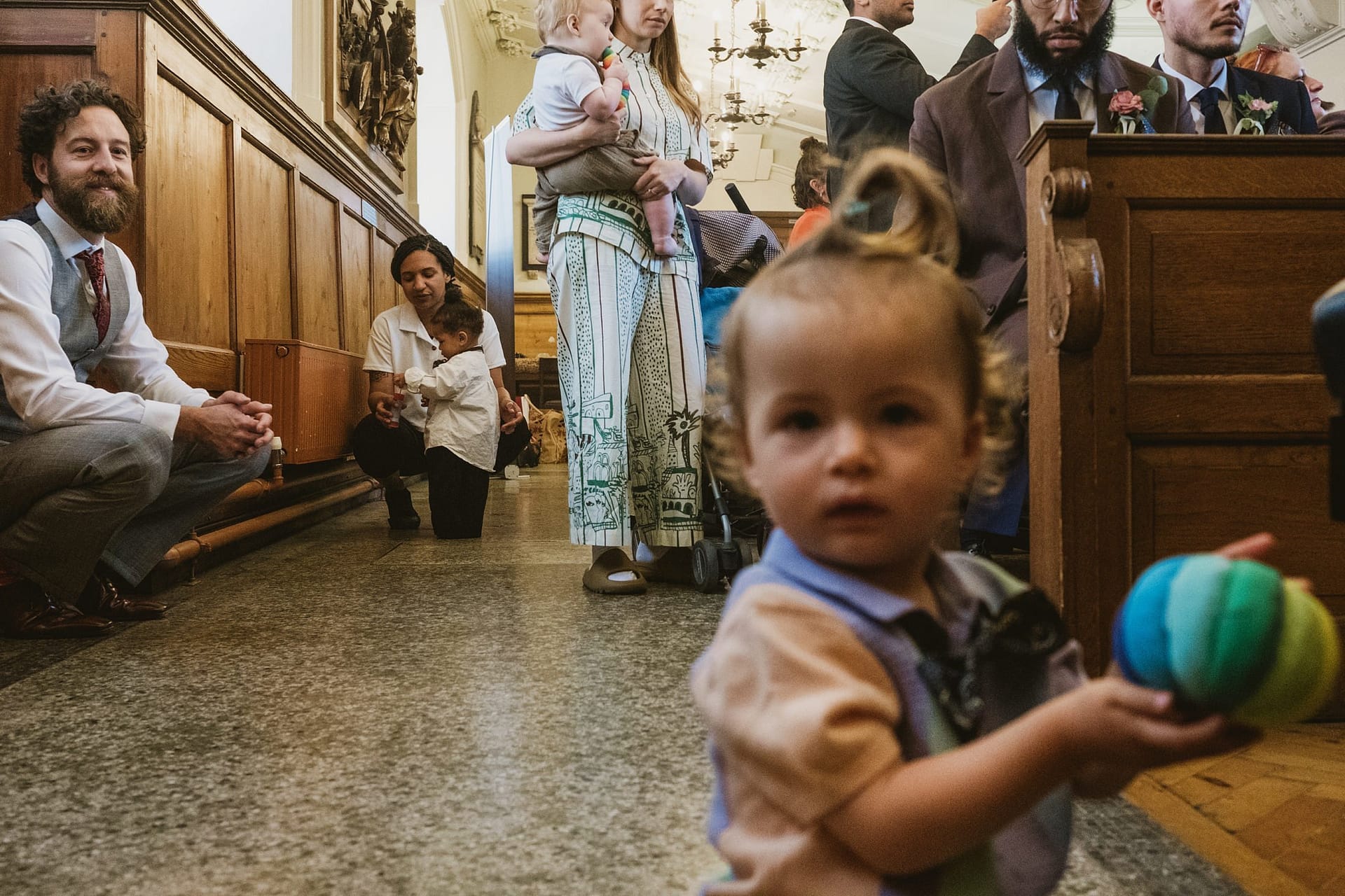 At a London ceremony, a little girl joyfully plays with a ball inside the church.