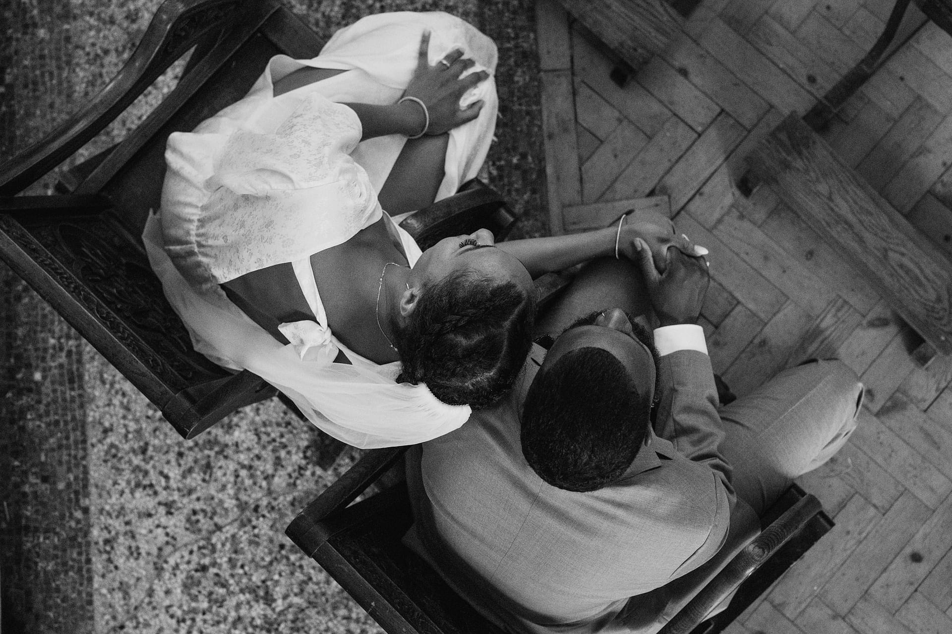 A black and white photo of a bride and groom sitting on chairs at their Greenwich Yacht Club wedding.