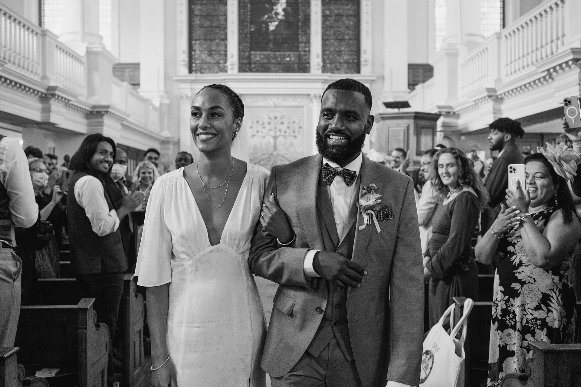 A bride and groom walking down the aisle of a church during their Greenwich Yacht Club wedding.