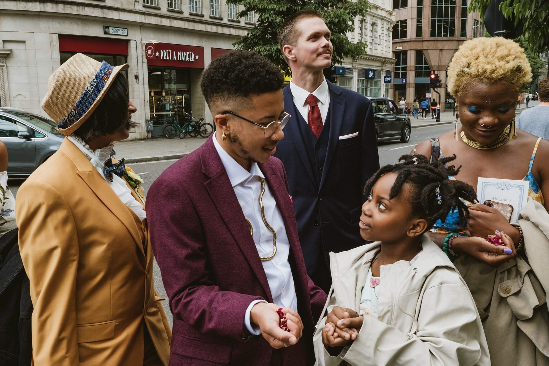 A group of people standing on a street with a little girl during a Greenwich Yacht Club wedding.