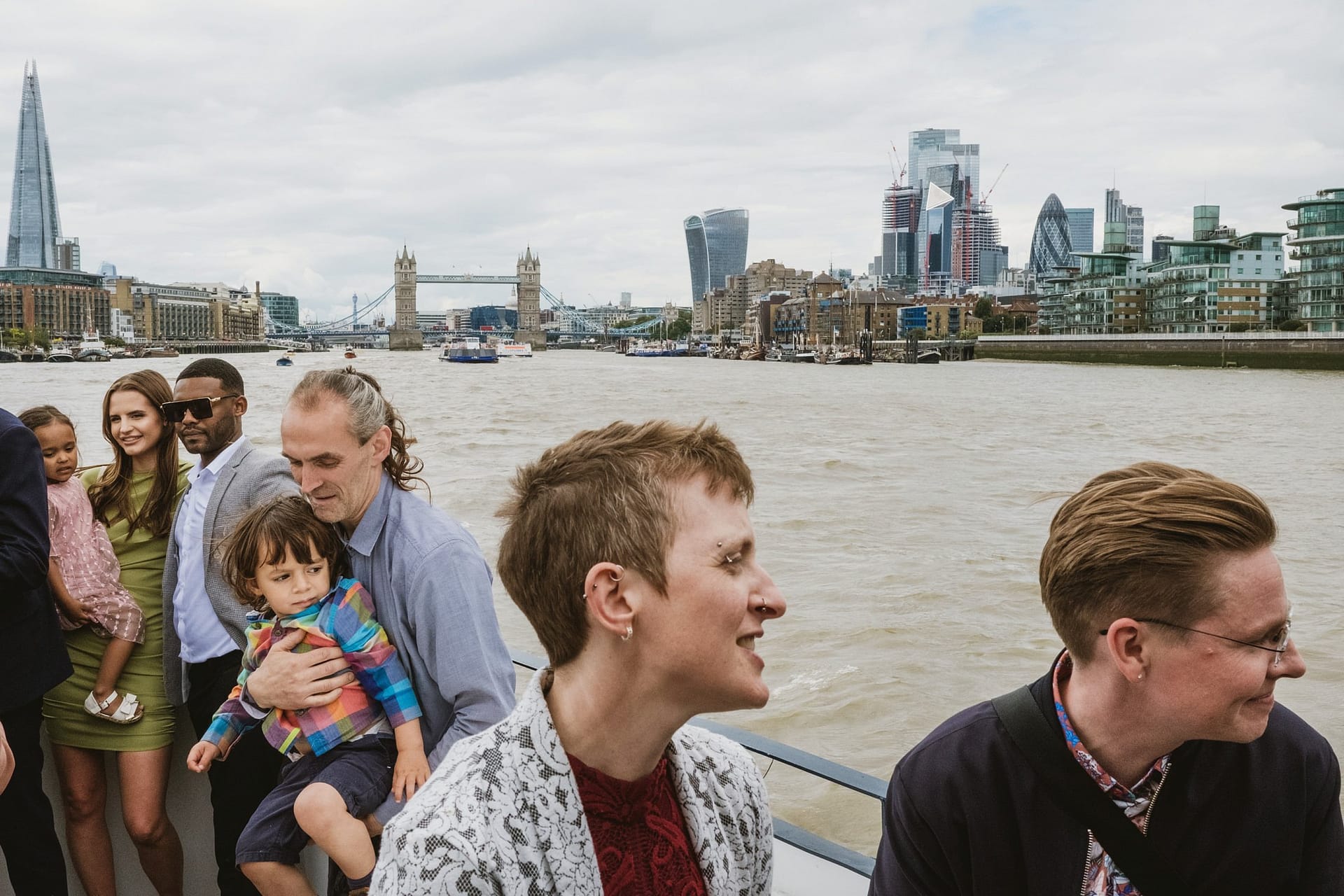A group of people on a boat enjoying a wedding celebration at the Greenwich Yacht Club on the River Thames.
