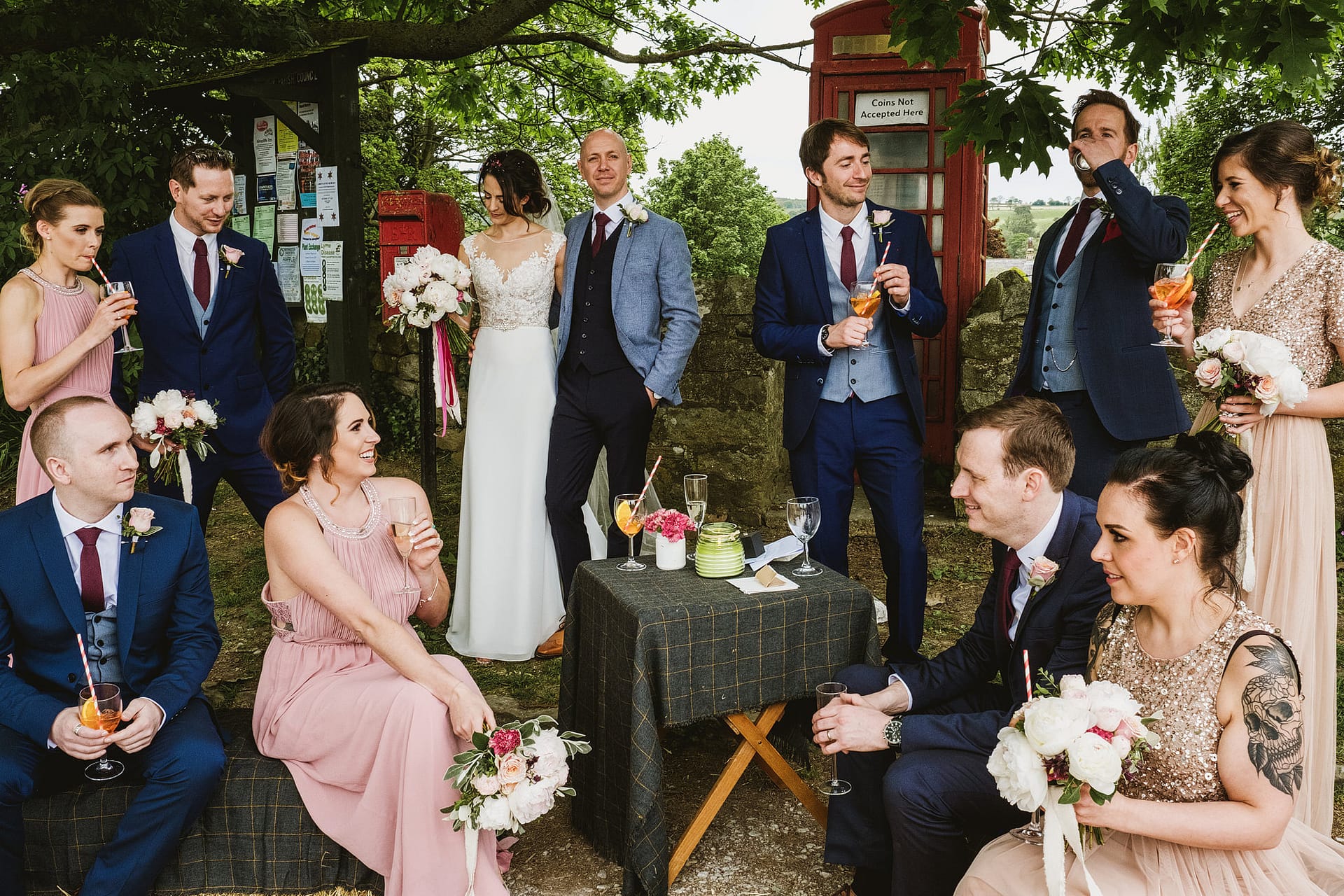 Leeds Wedding Photography by York Place Studios. Bride, groom and wedding party gather outside, in front of a british red telephone box