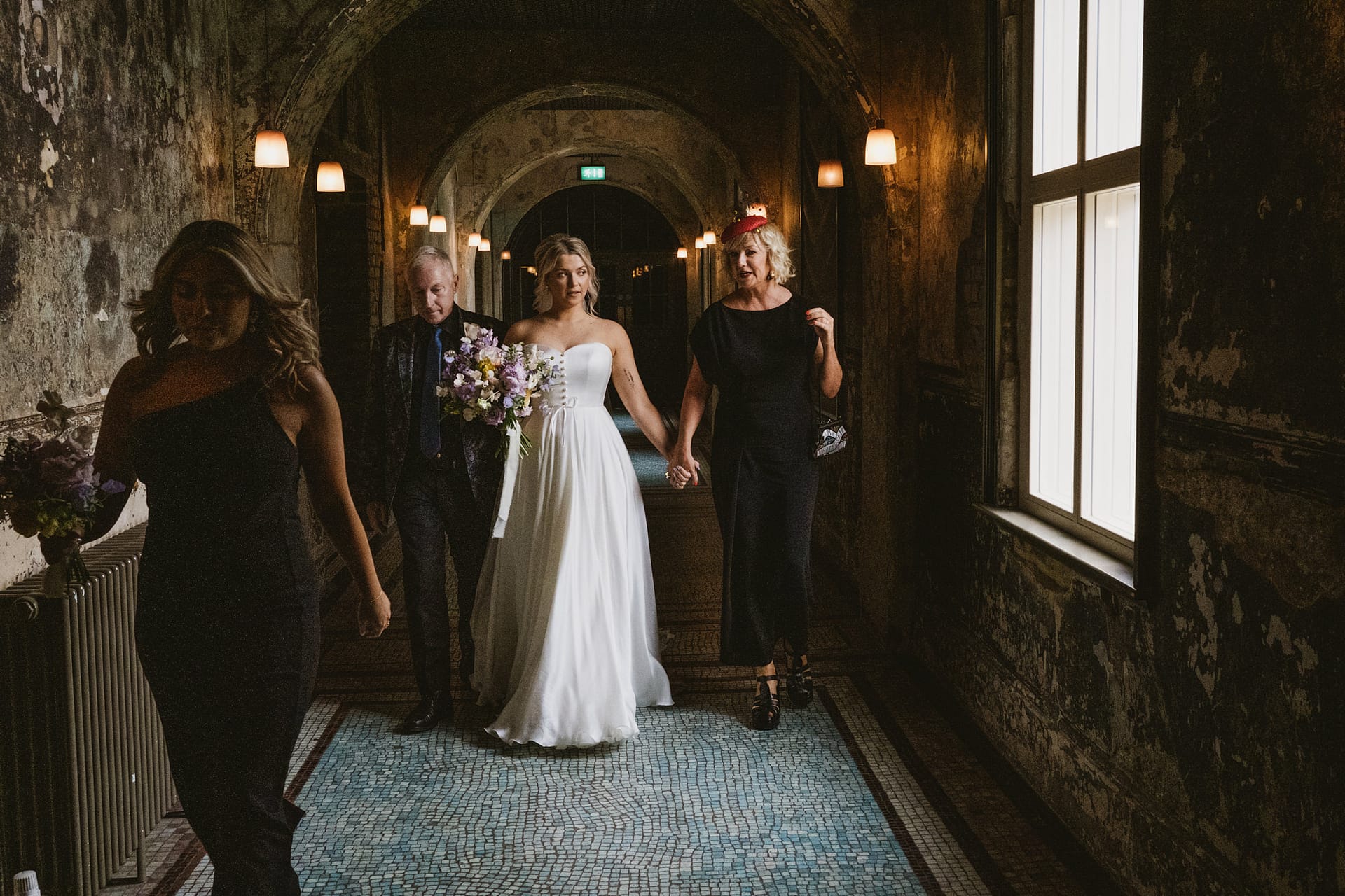 Bride walking down aisle with family.