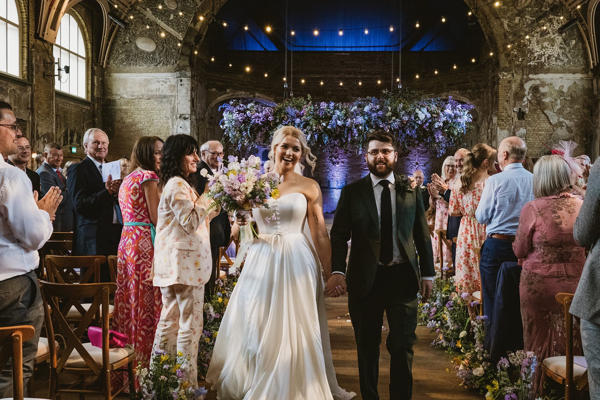Bride and groom walking down the aisle, smiling.