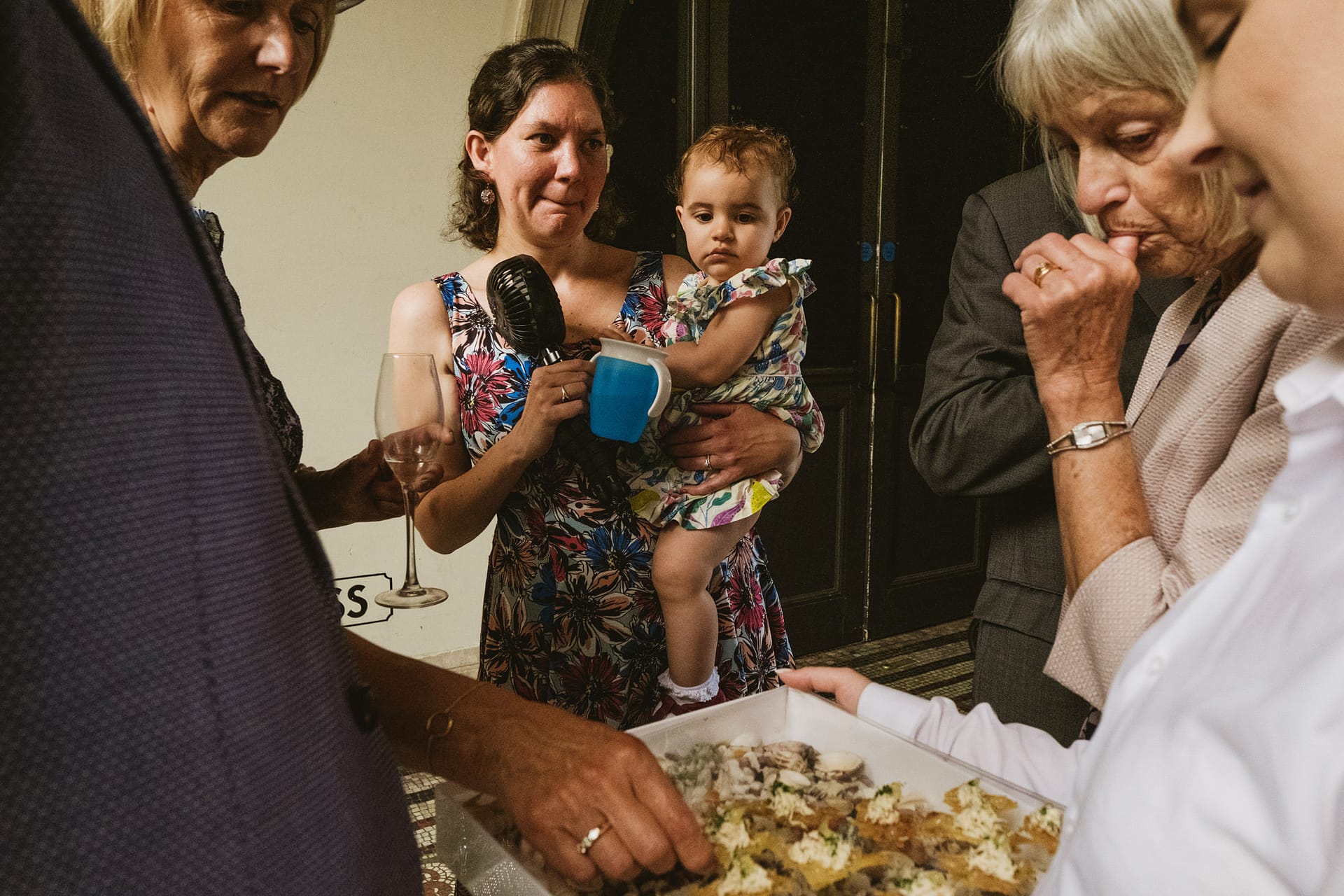 Group gathered with baby and food tray.