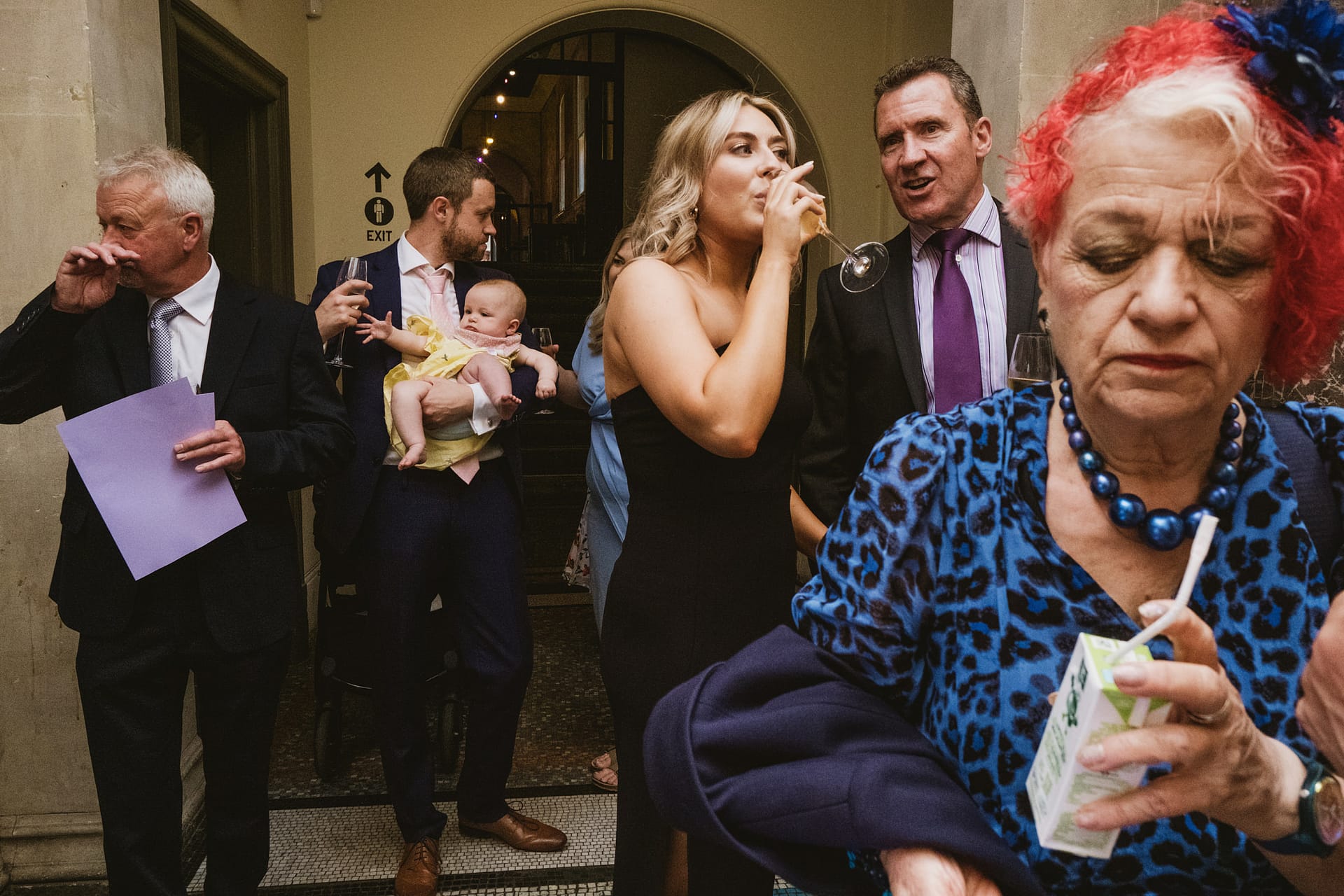 People socialising at a formal event, drinking and chatting.