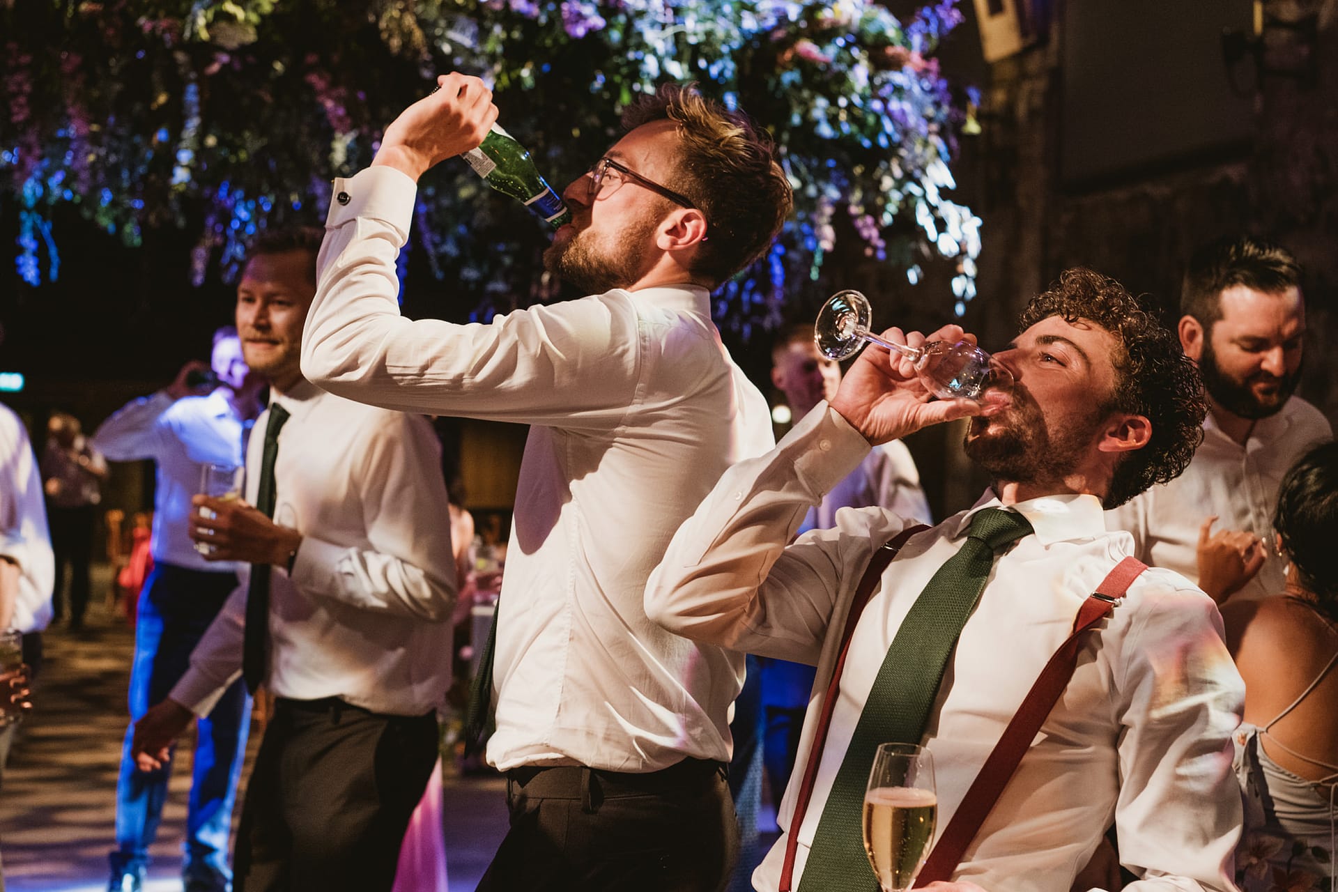 Men drinking and dancing at party celebration.
