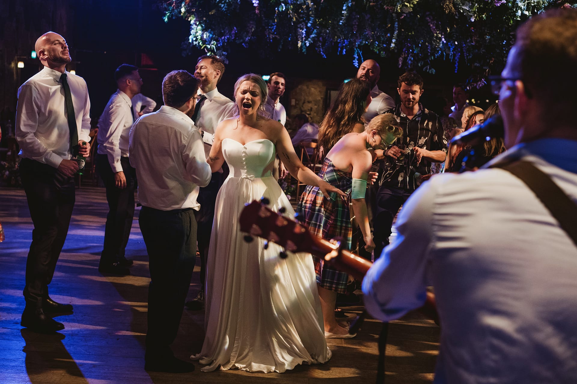 Wedding guests dancing with live music entertainment.