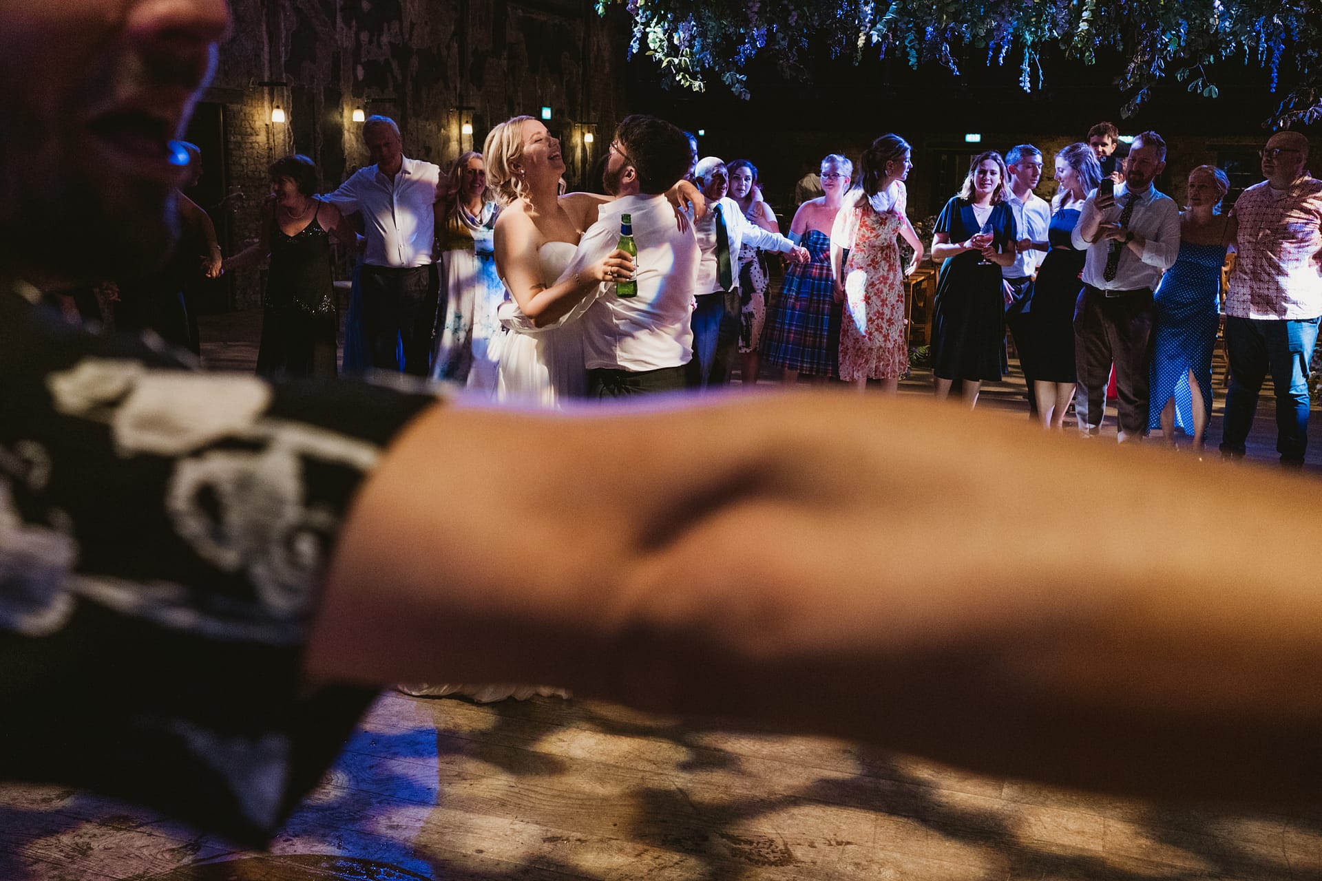 Couple dancing at a wedding surrounded by guests.