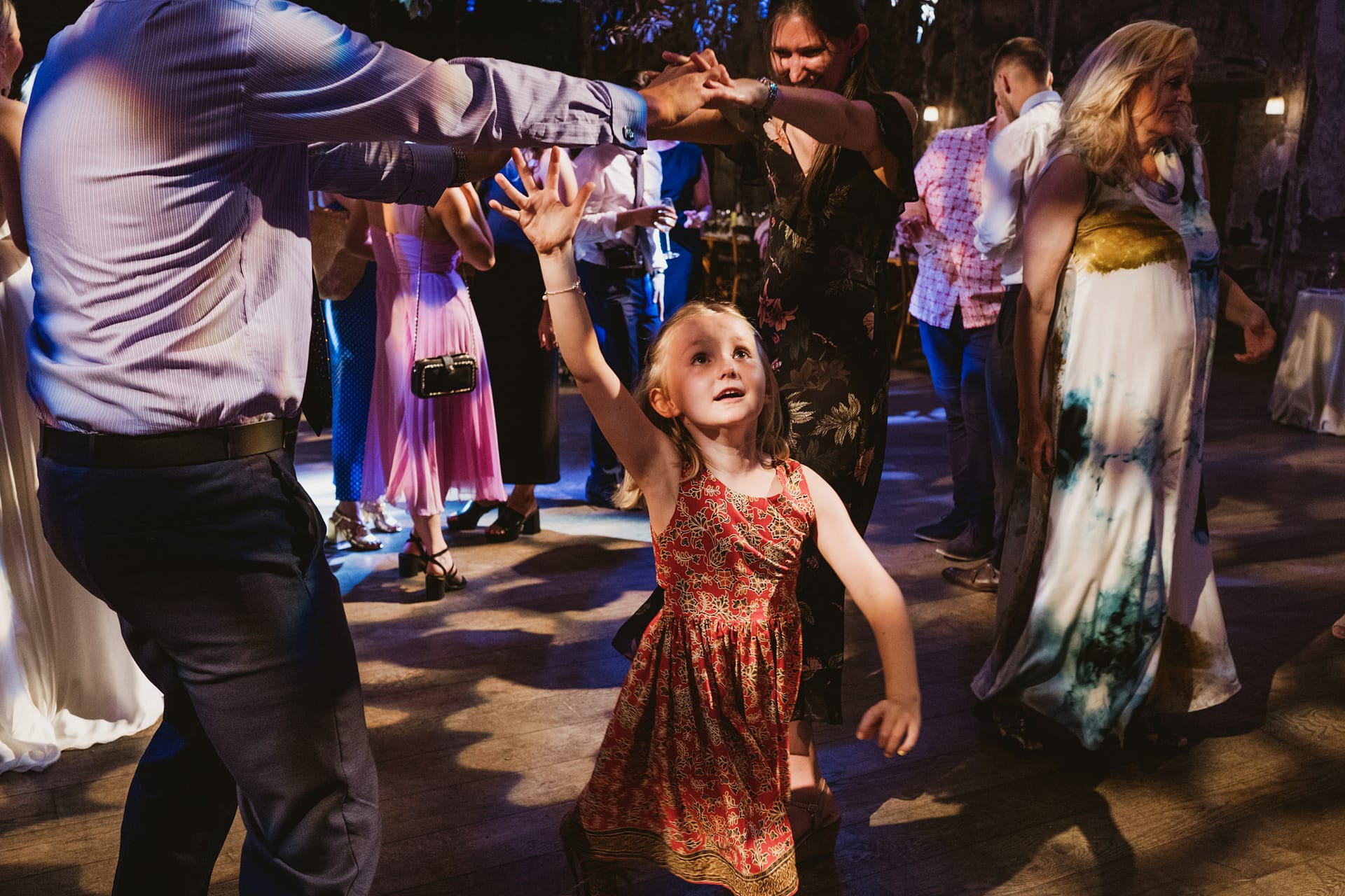 Young girl dancing joyfully at a lively event.