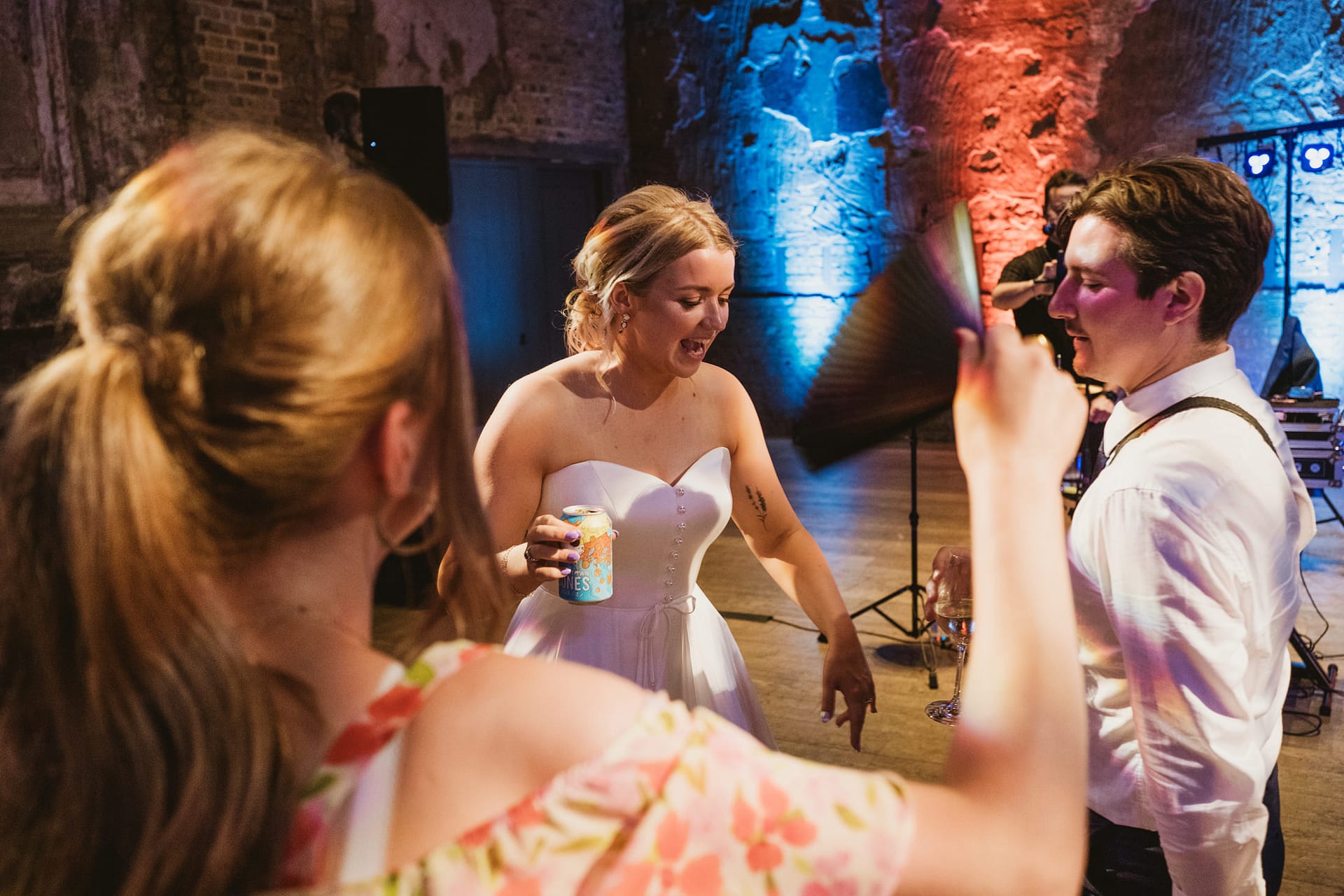 Wedding guests dancing and socialising indoors.