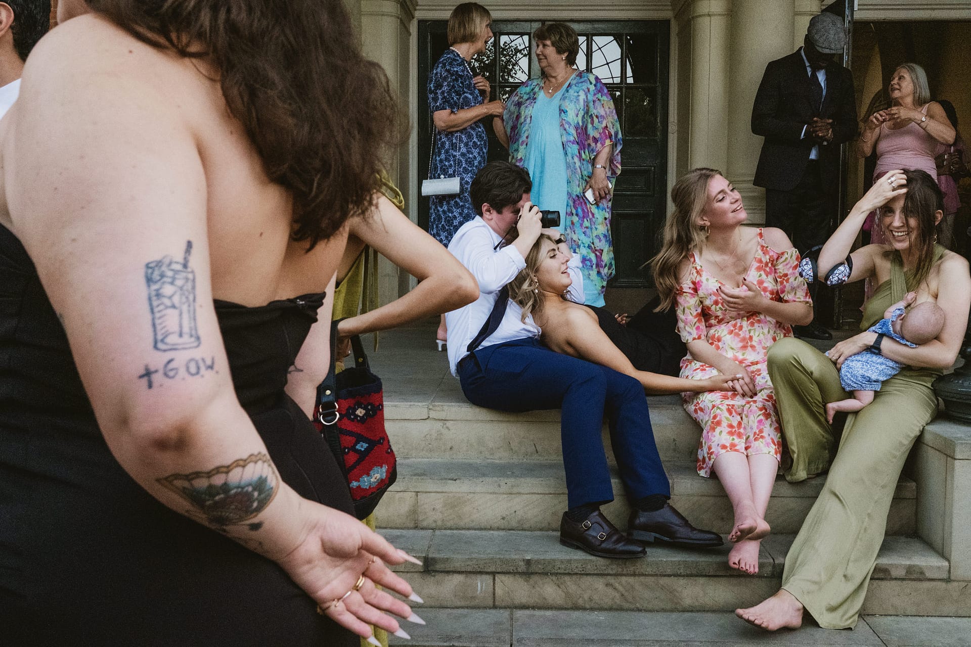 Group relaxing on steps at a gathering.