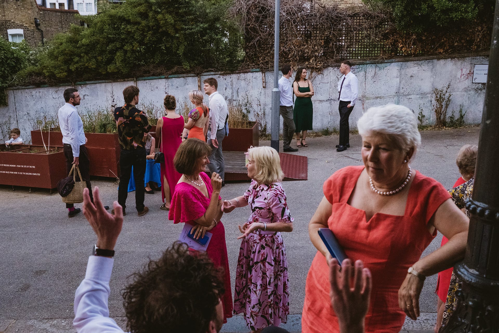 People socialising outdoors in colourful outfits.