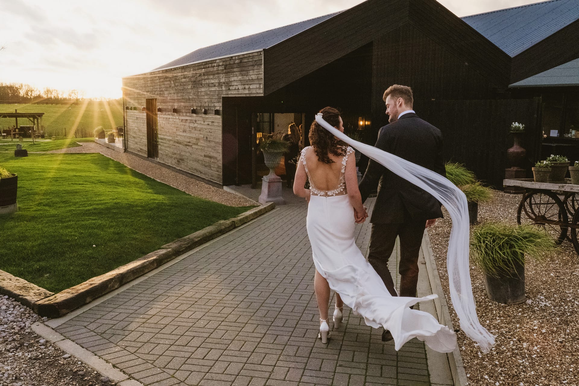 Couple walking towards sunset on wedding day.