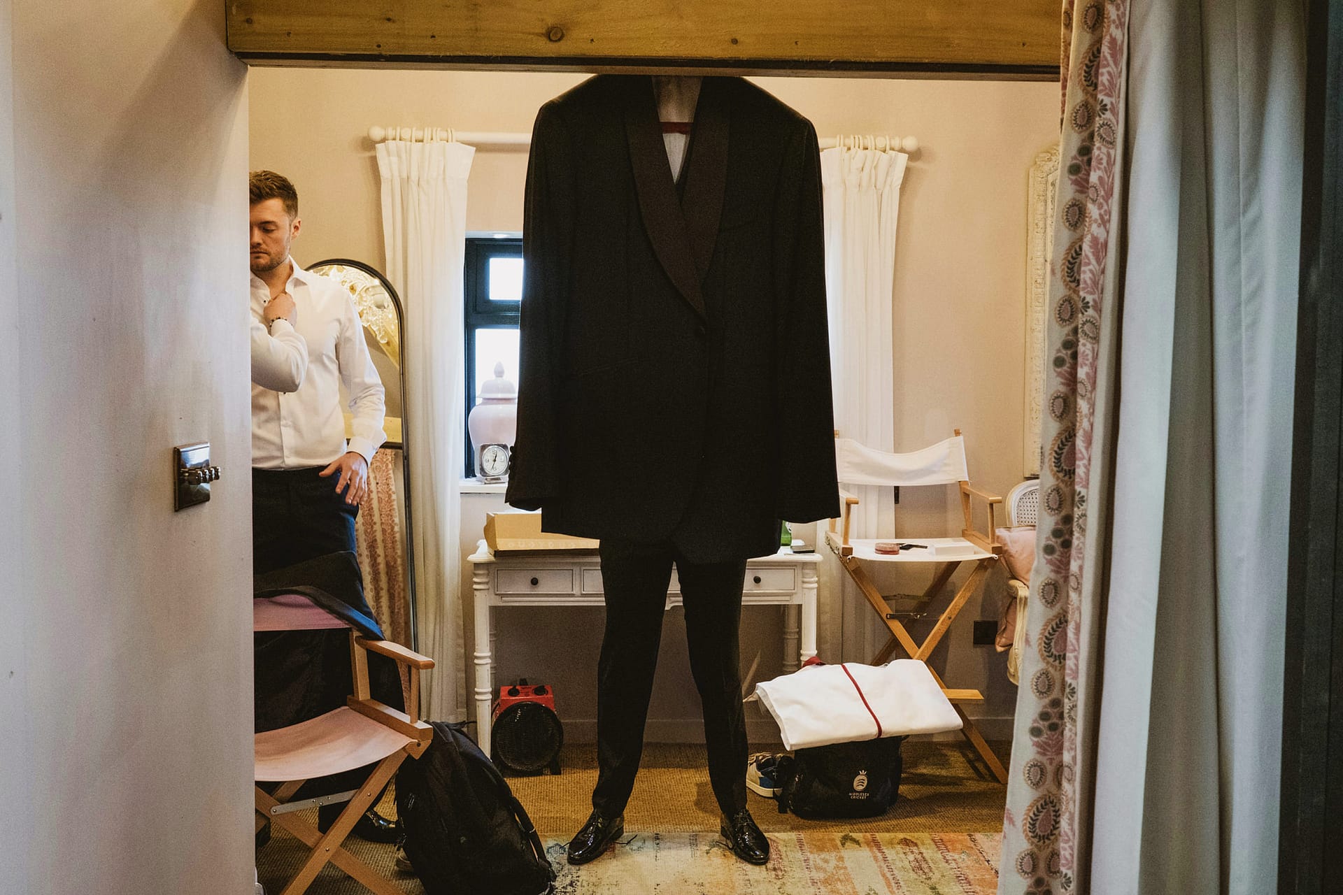 Man preparing suit in dressing room.