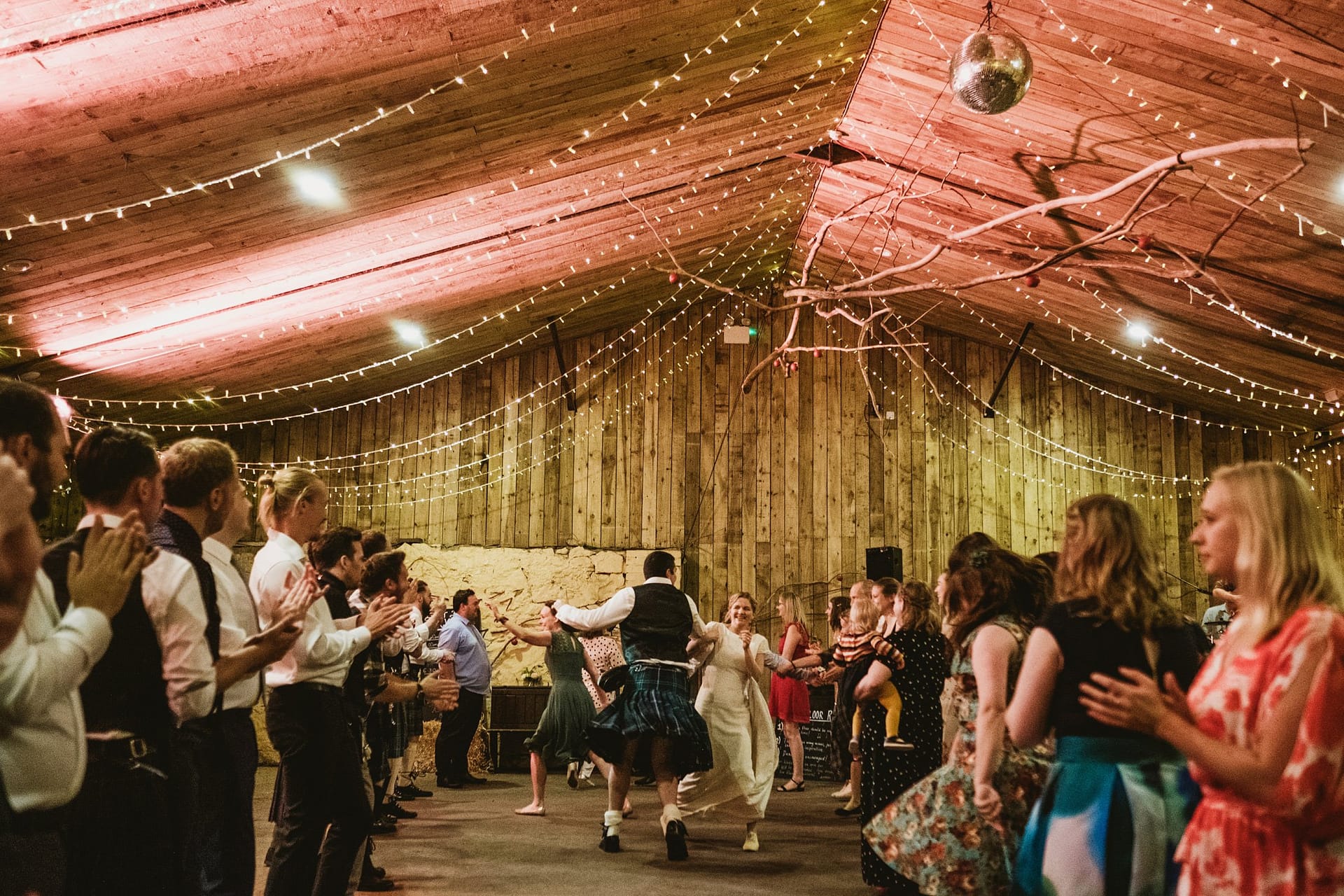 bride and groom ceilidh dancing in the barn at Comrie Croft