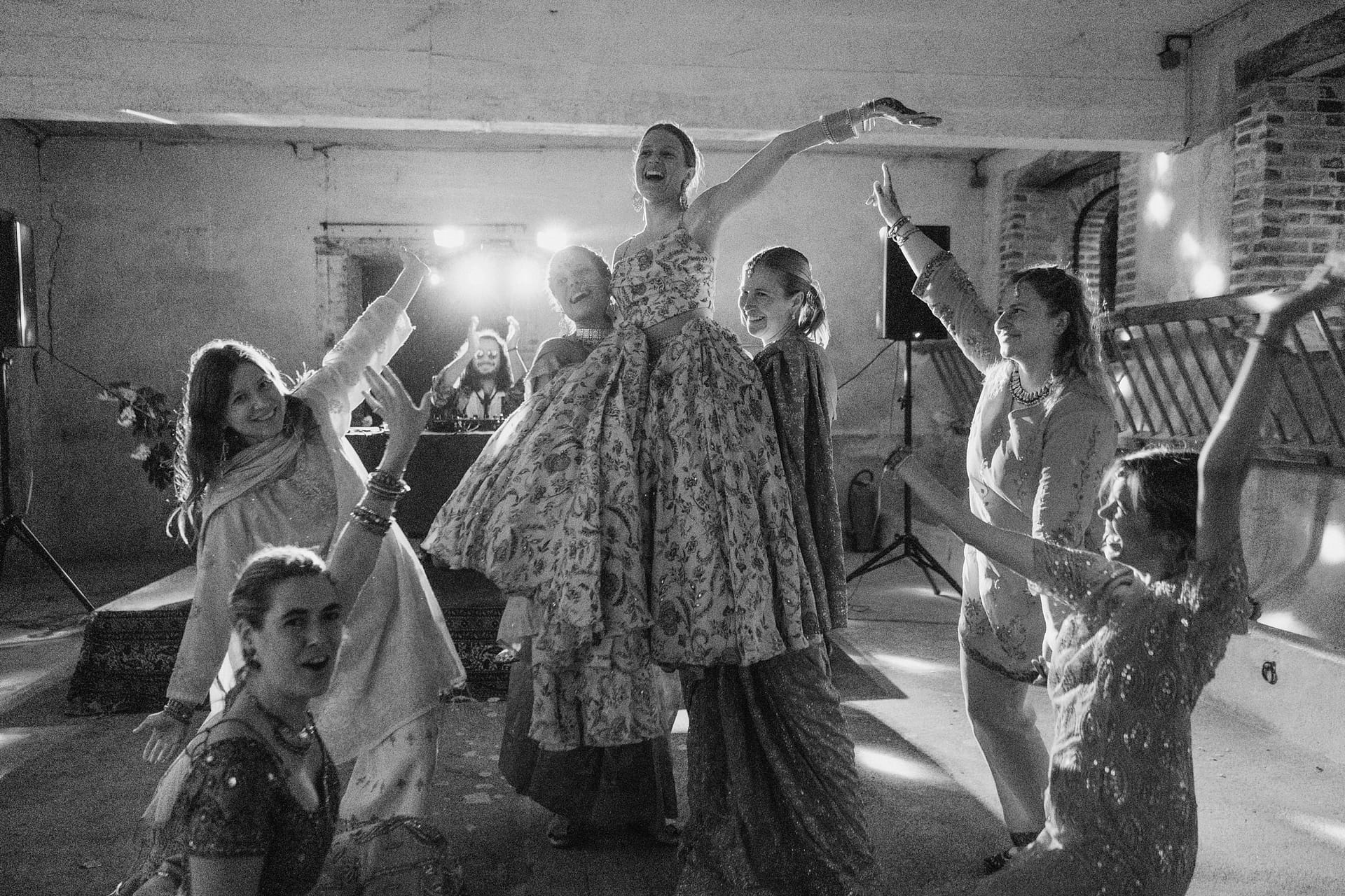 Indian wedding dancing at Chateau du Fey in France. Bride lifted into the air by her bridesmaids.