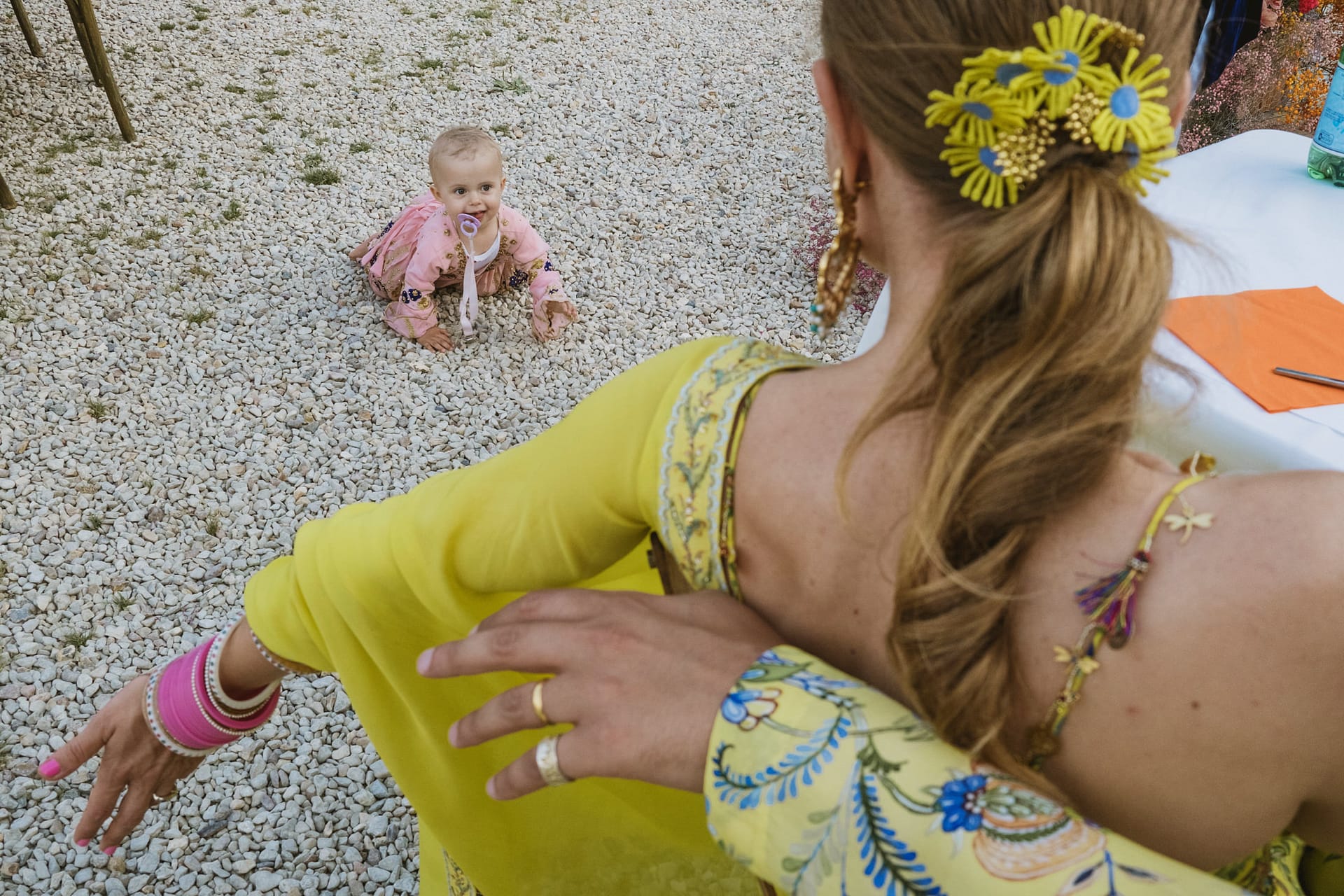 Little baby looks uo at the bride at the Indian wedding reception