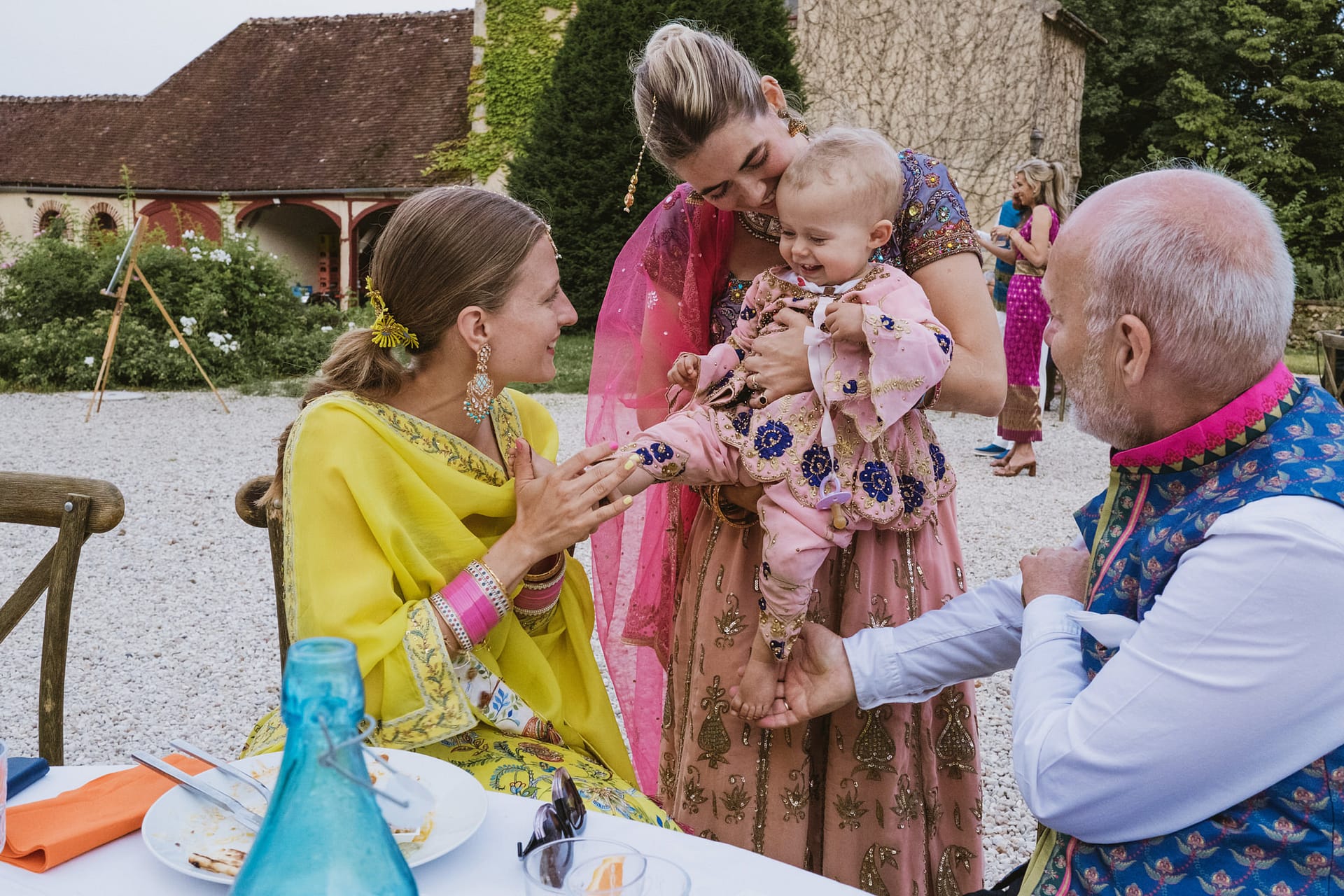bride meets her friend's baby for the first time at her wedding reception at Chateau du Fey in France