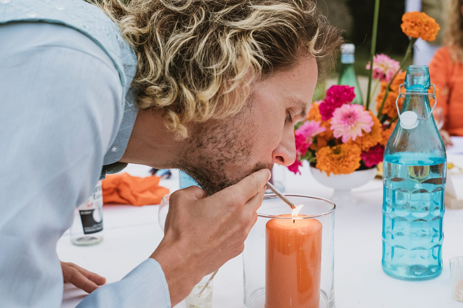 A wedding guest lights his cigarette on a candle at Chateau du Fey in France
