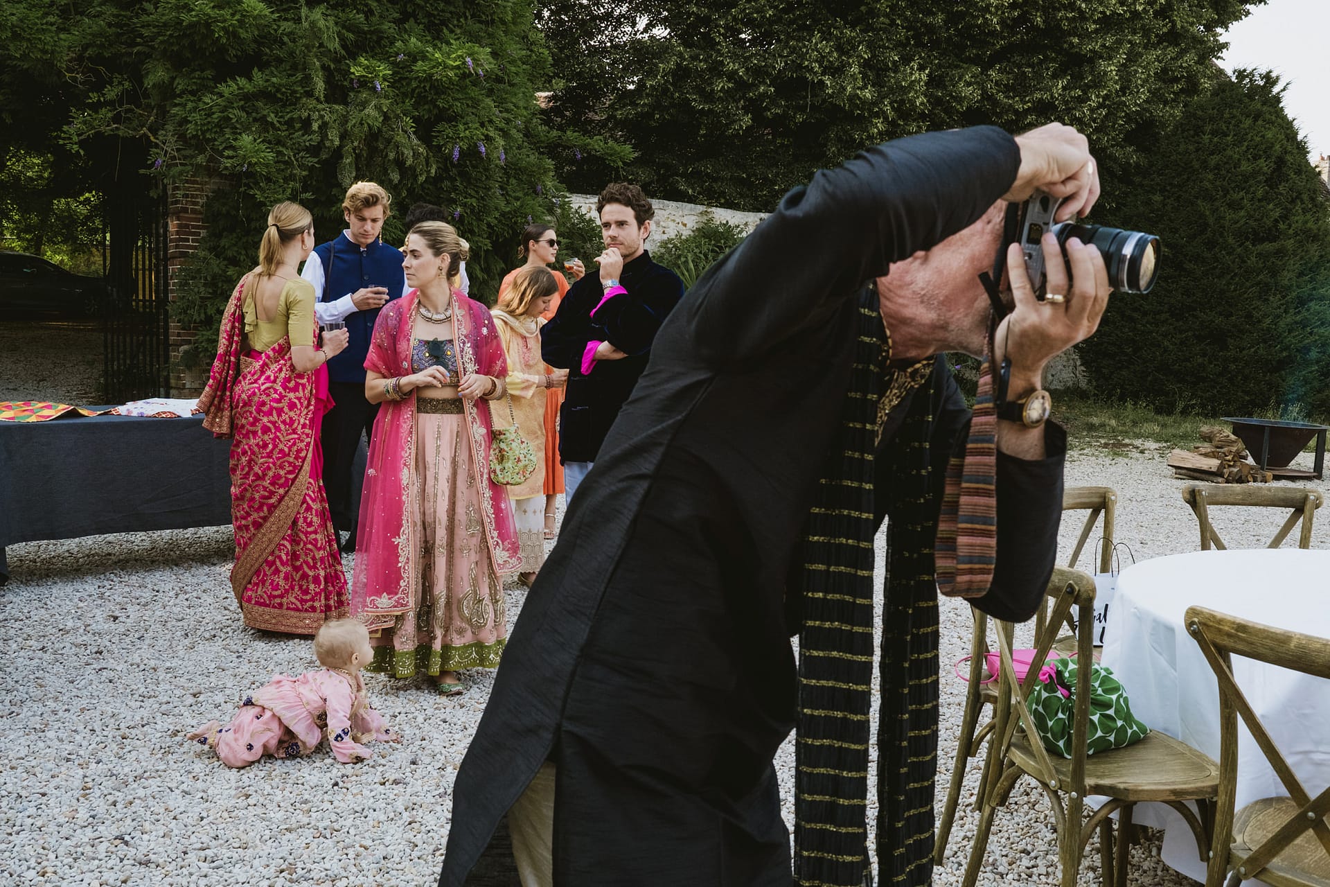 wedding guests standing in the background whilst one guest photographs the wedding at Chateau du Fey