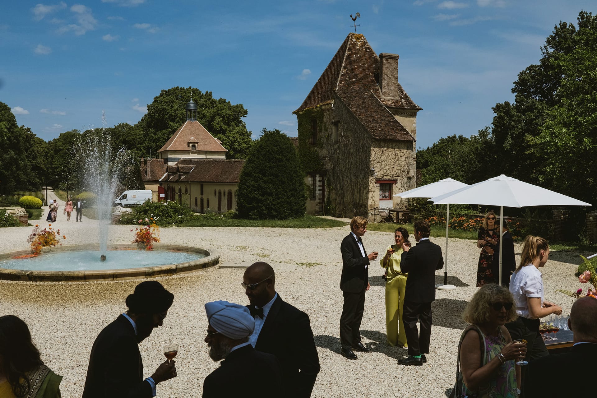 The Chateau du Fey wedding reception begins. Guests silhouetted and lit by the French sunlight