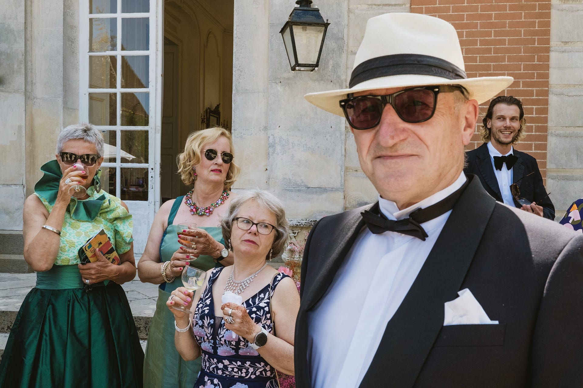 wedding reception at Chateau du Fey in France. Wedding guests drinking and laughing