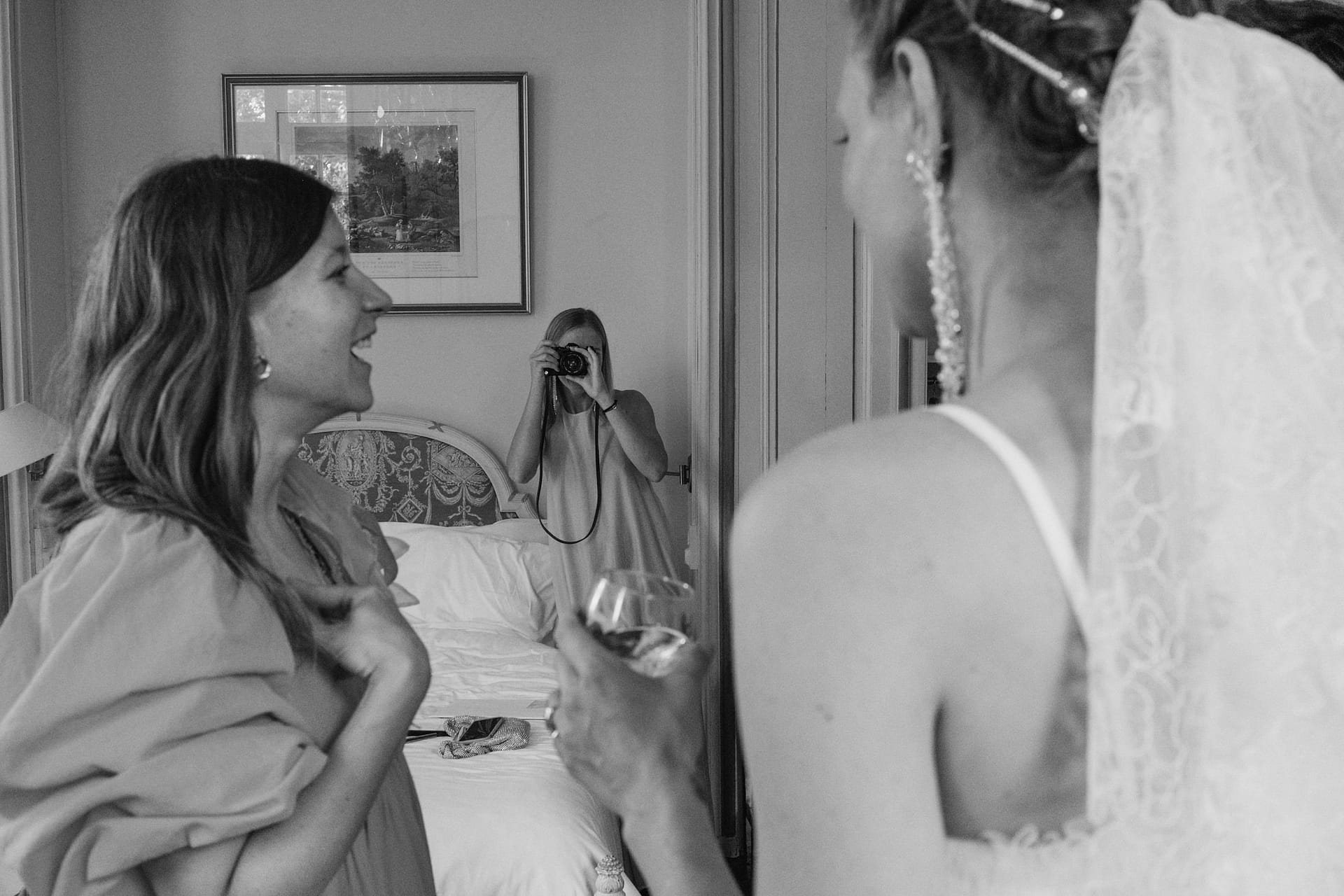 bride having her photo taken by a bridesmaid at Chateau du Fey in France