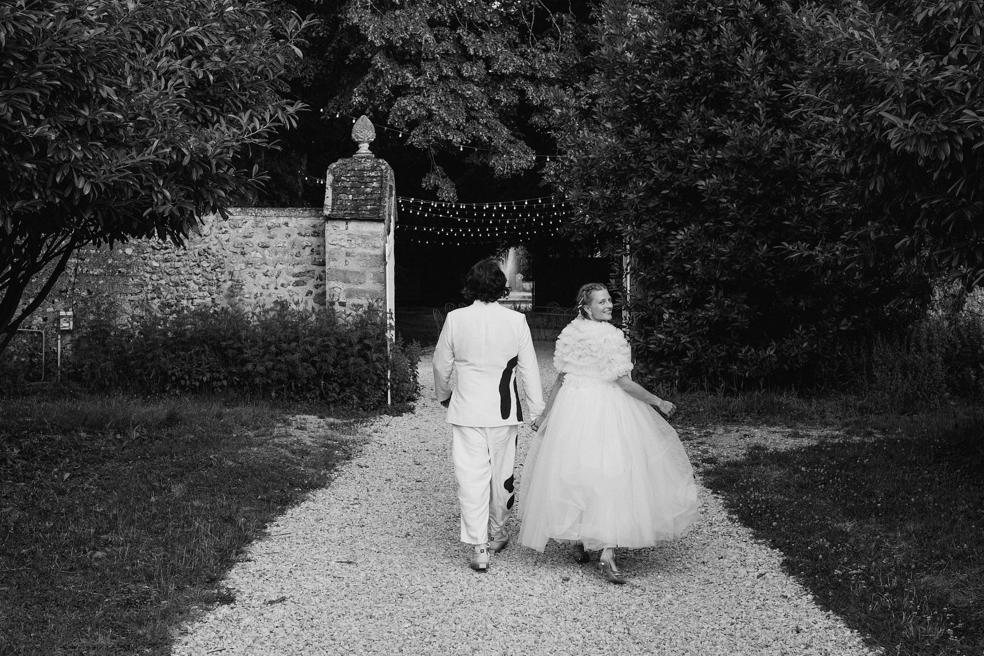the bride and groom taking a little walk at the Chateau du Fey in France. Black and white portrait.