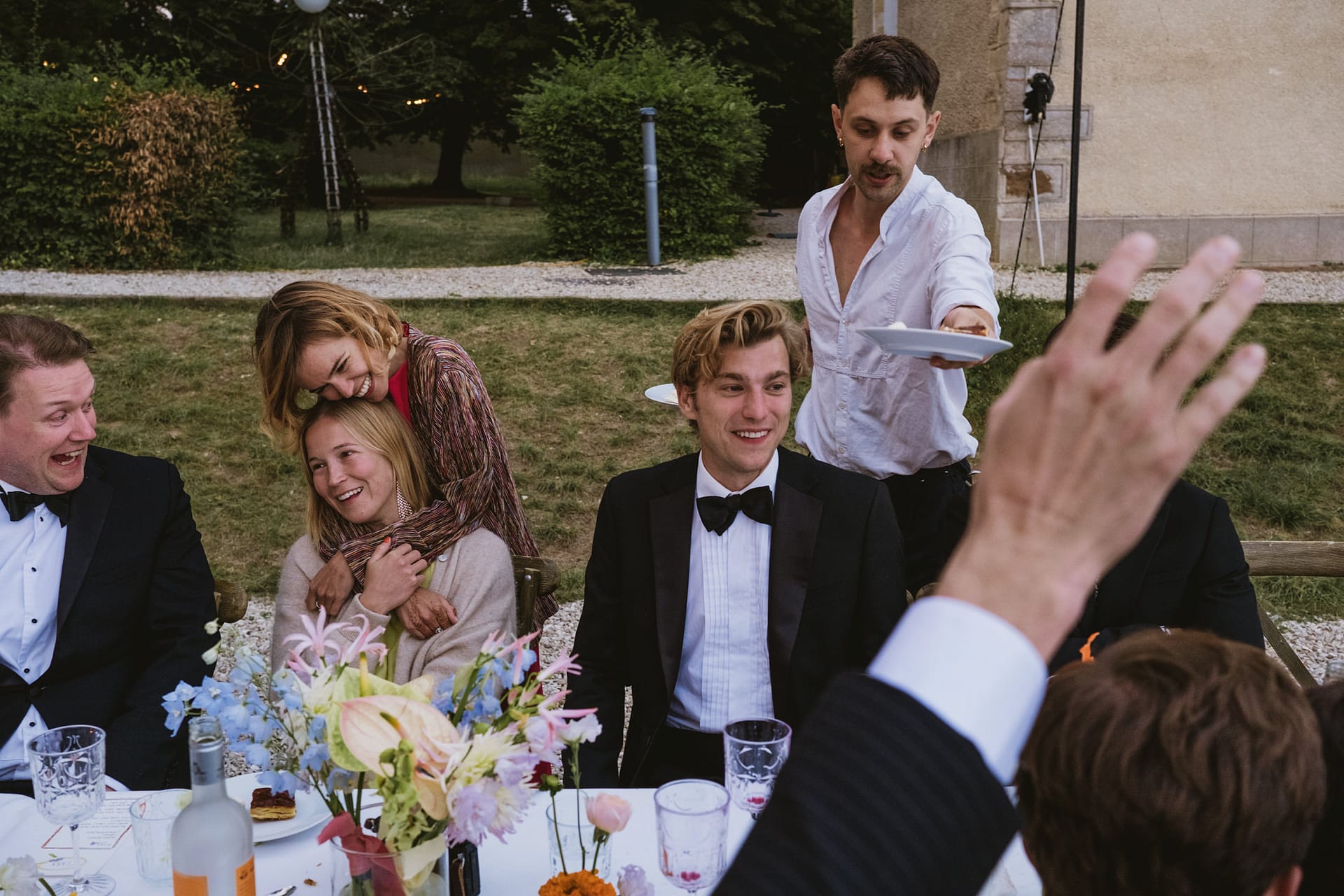 wedding guests laughing at the table whilst desserts are served at Chateau du Fey in France