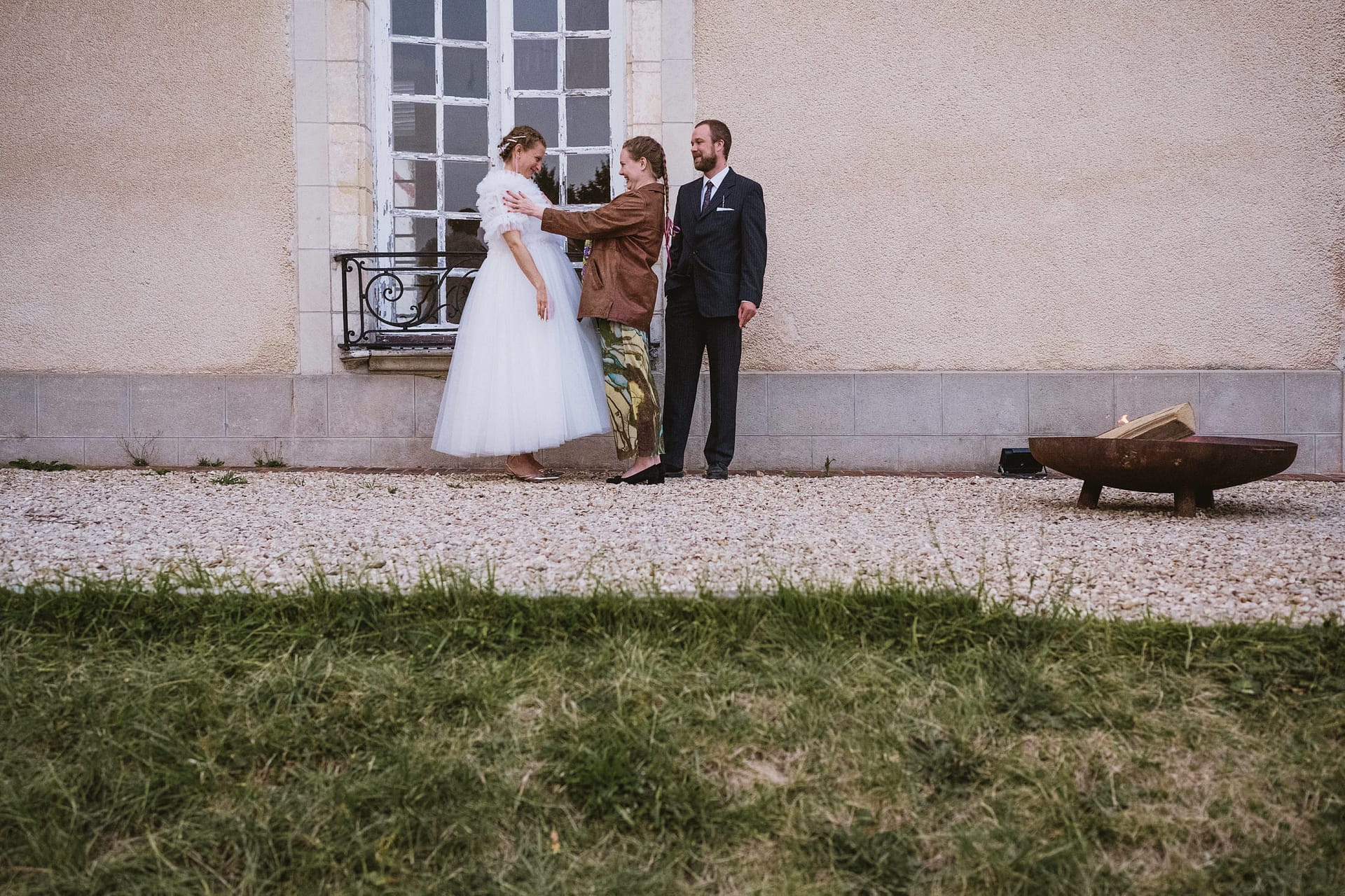 bride is affectionately embraced by a wedding guest in the evening reception at Chateau du Fey