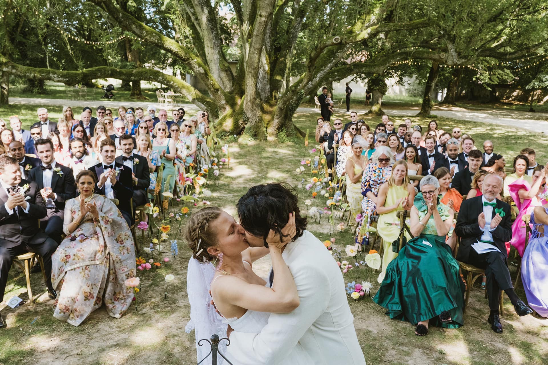 Chateau du Fey wedding photographer. The bride and groom share a passionate kiss during the ceremony whilst the guest cheer