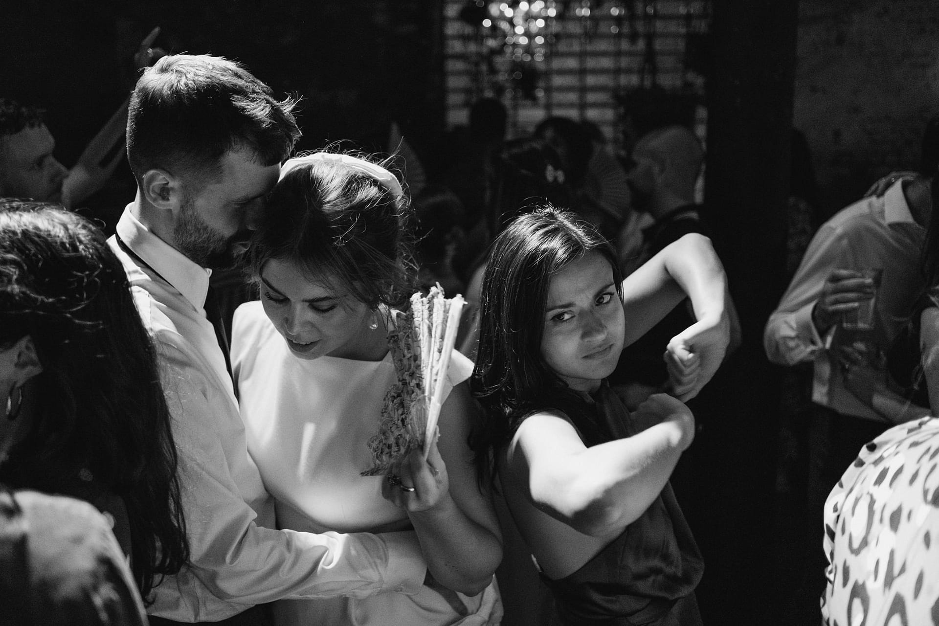 People dancing and embracing at a party.