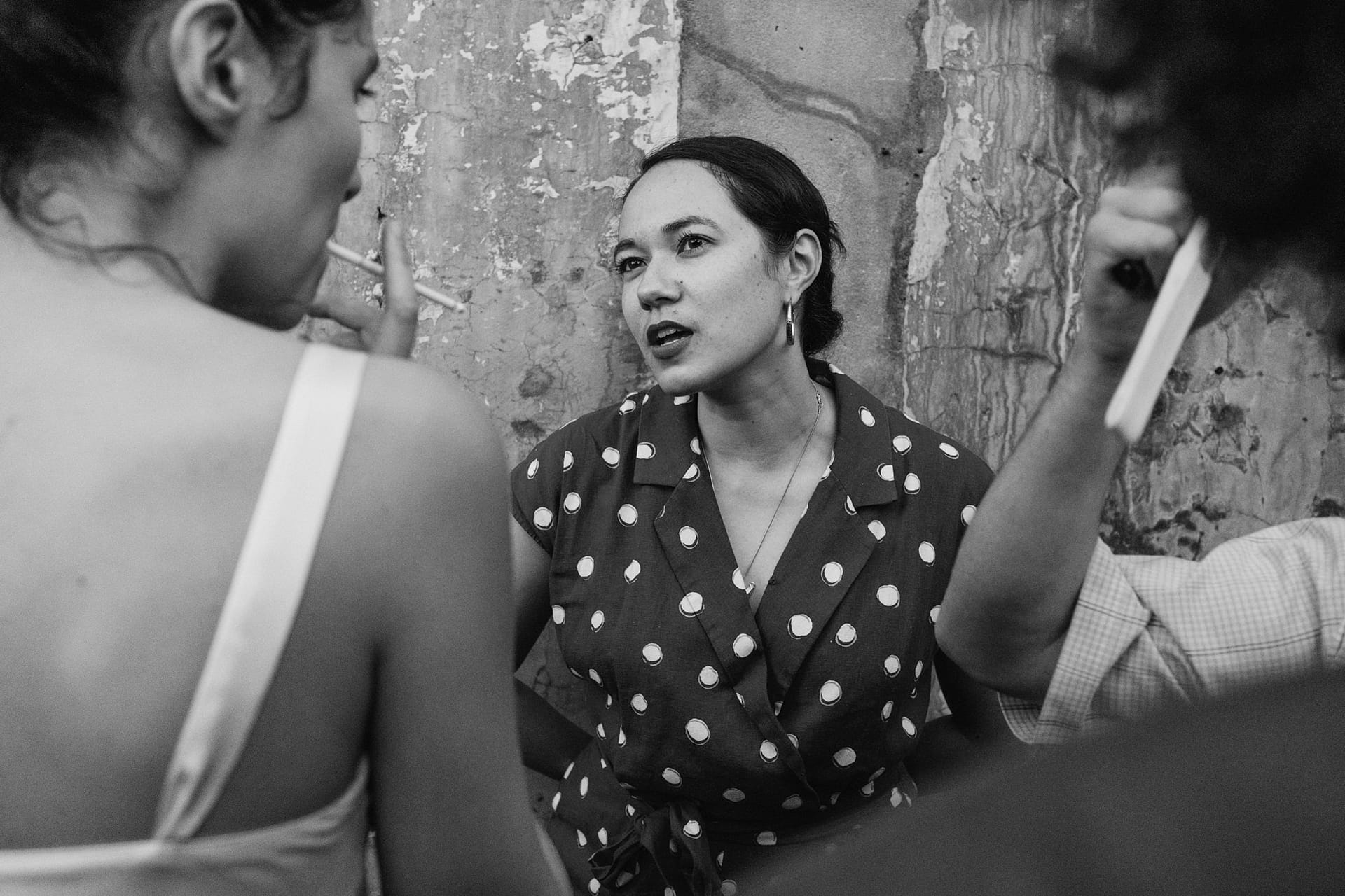Woman talking to two others in conversation.