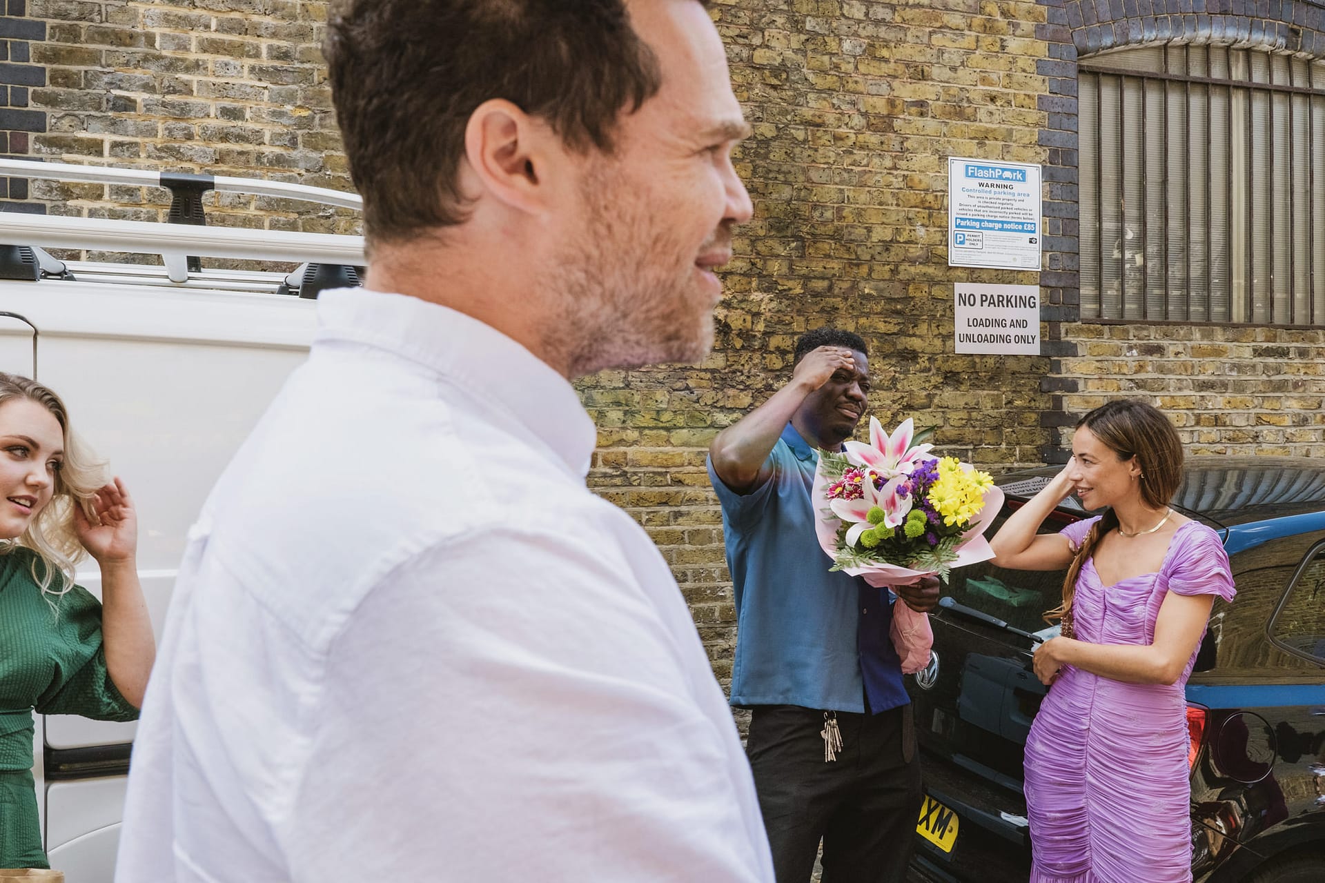 Man with flowers talking to woman on street