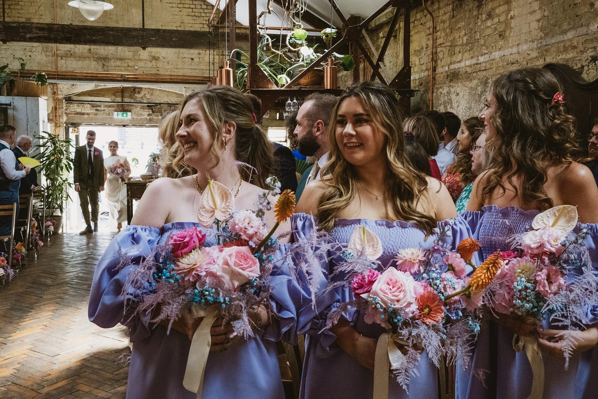 Bridesmaids smiling at wedding ceremony in rustic venue Clapton Country Club