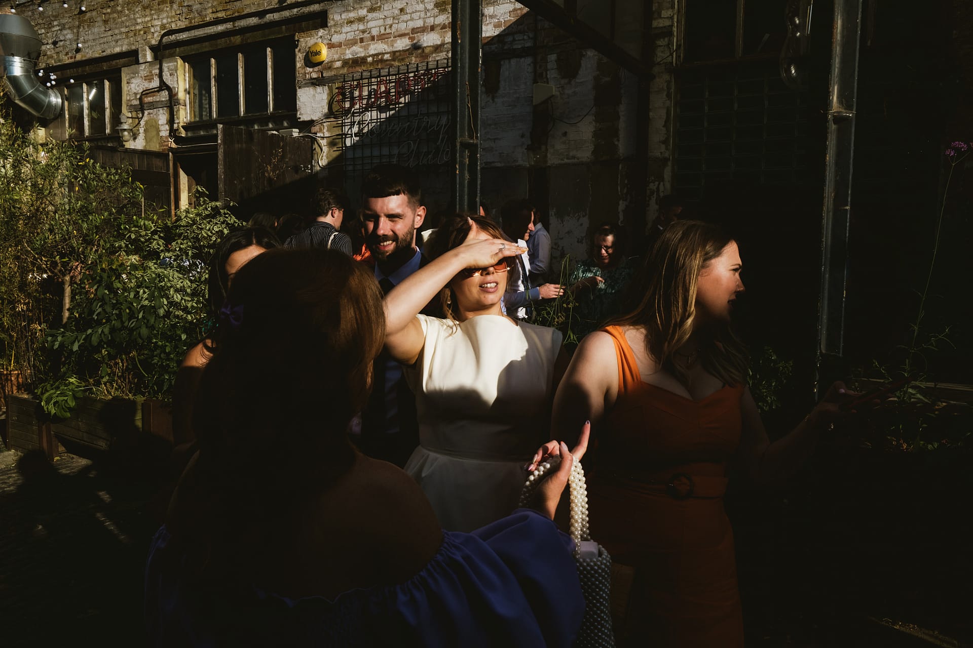 People socialising outdoors in afternoon sun.