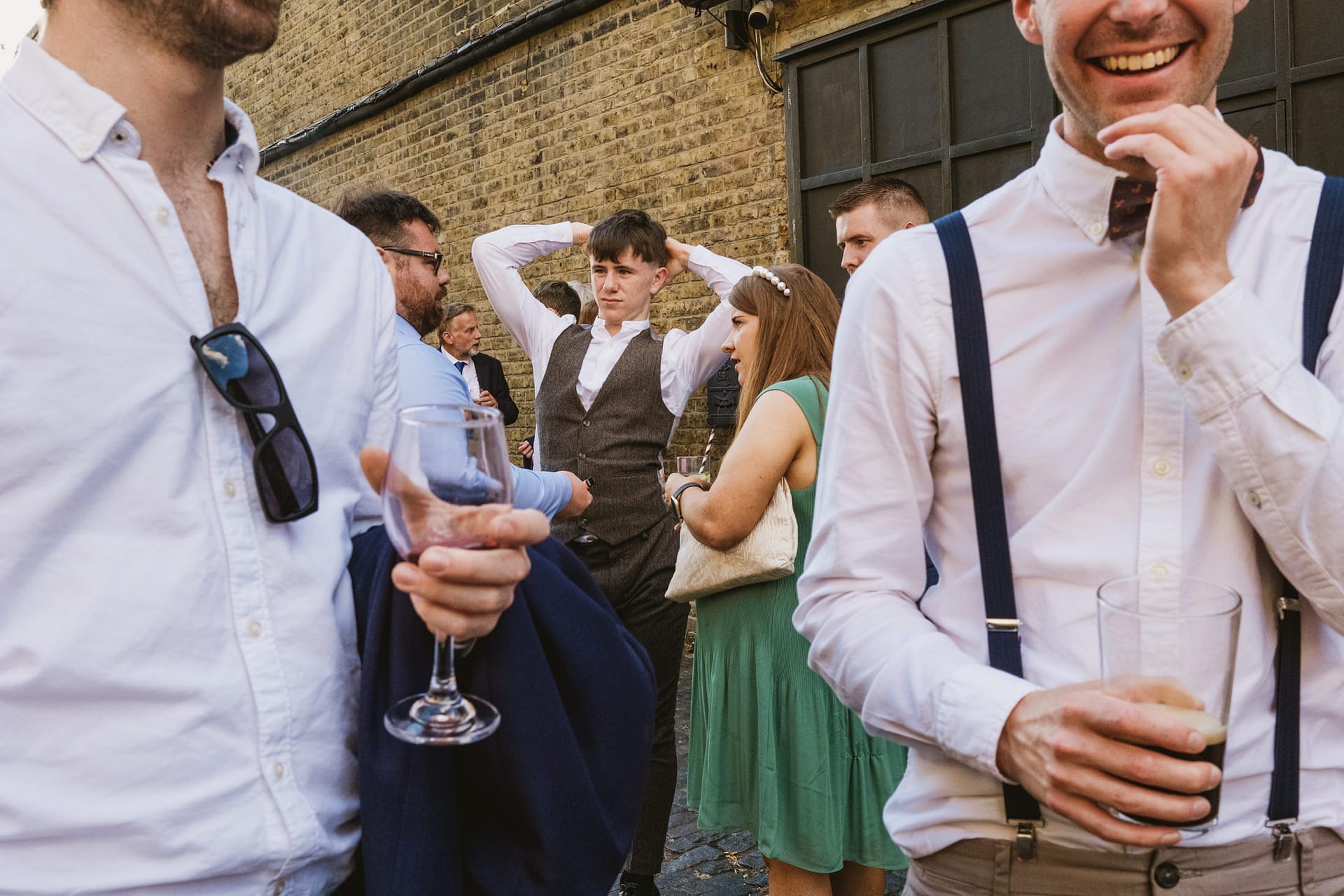 People socialising outdoors with drinks.
