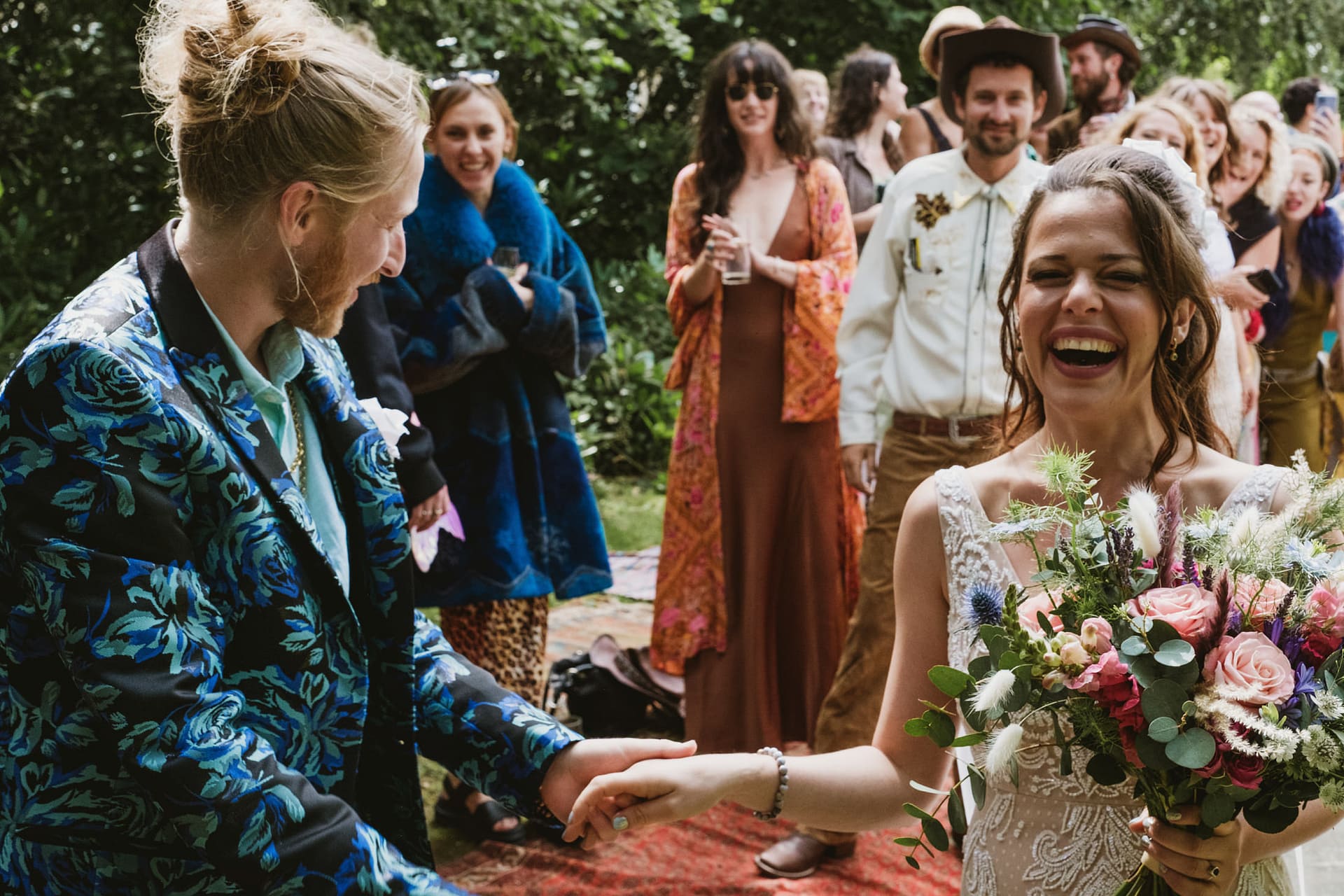 Happy couple celebrating wedding outdoors with friends.