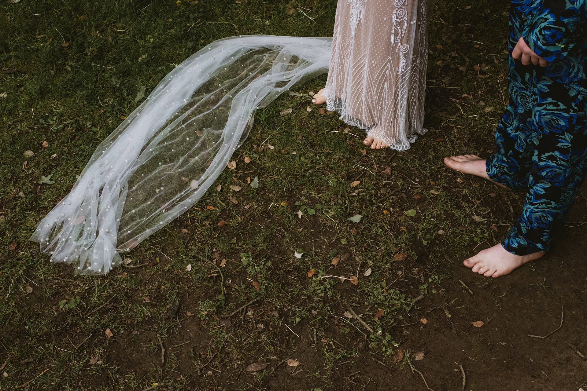 Barefoot wedding couple standing on grass.