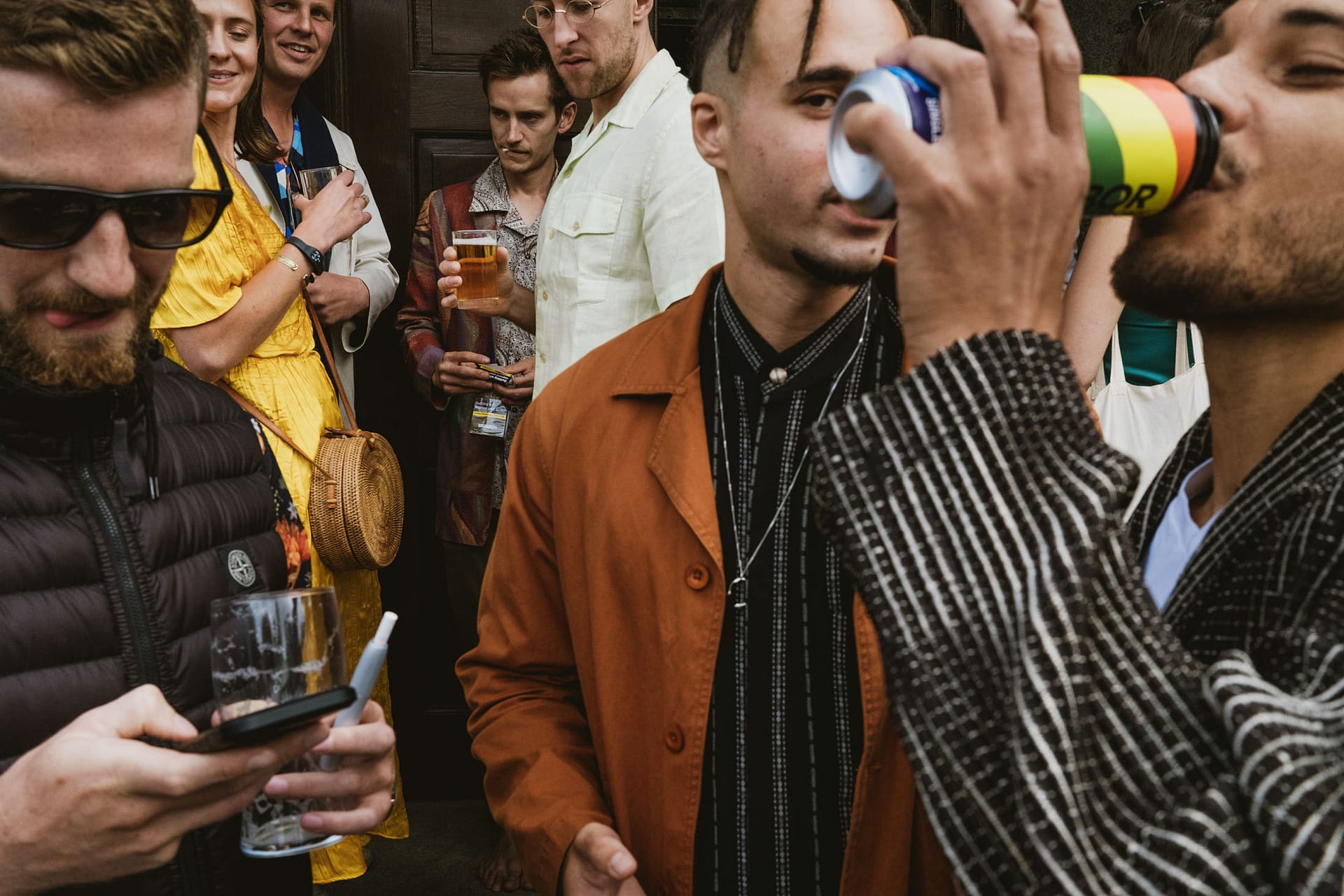 Group of people socialising and drinking outdoors.