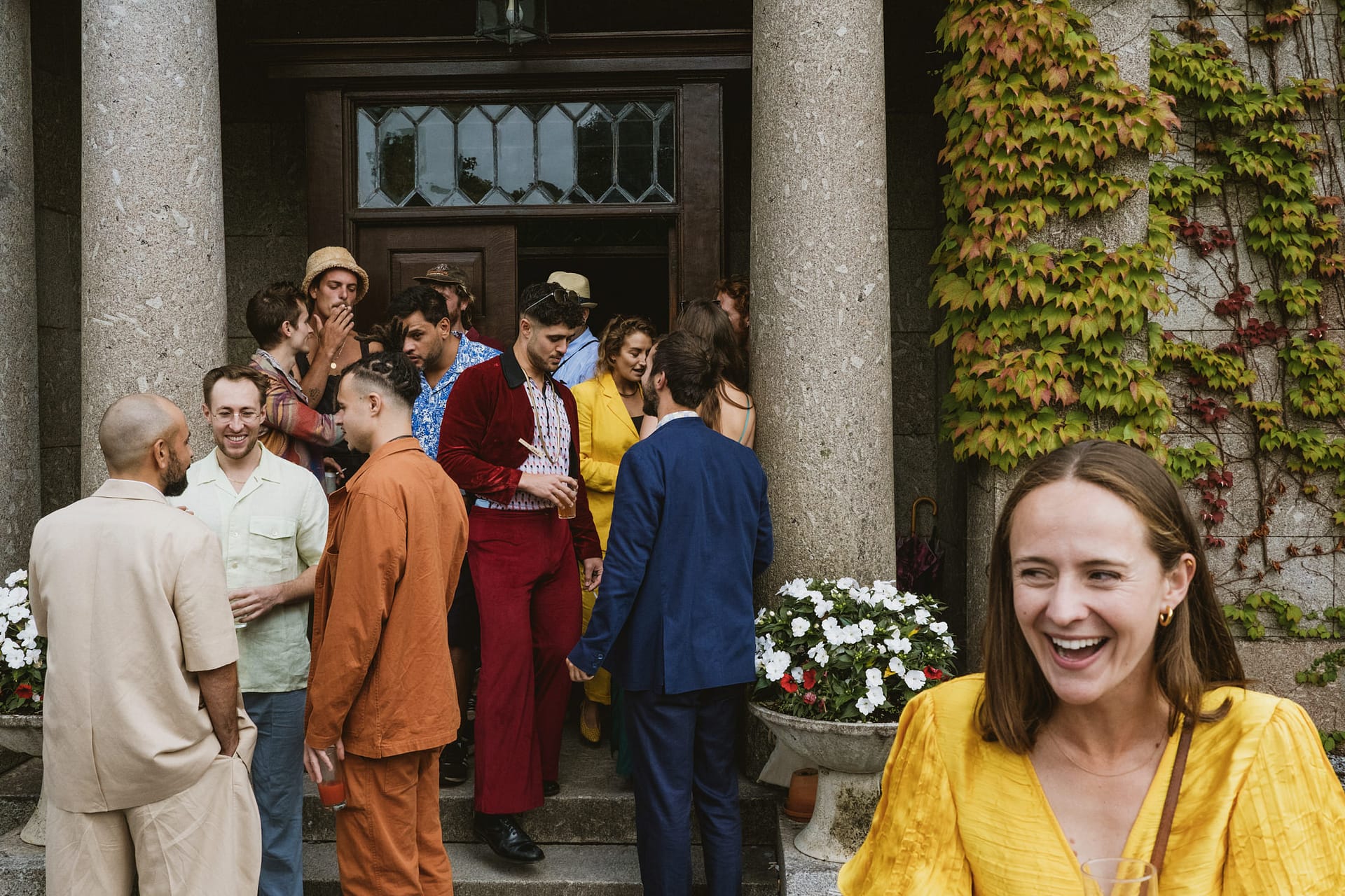 Group of people socialising outside a building entrance.