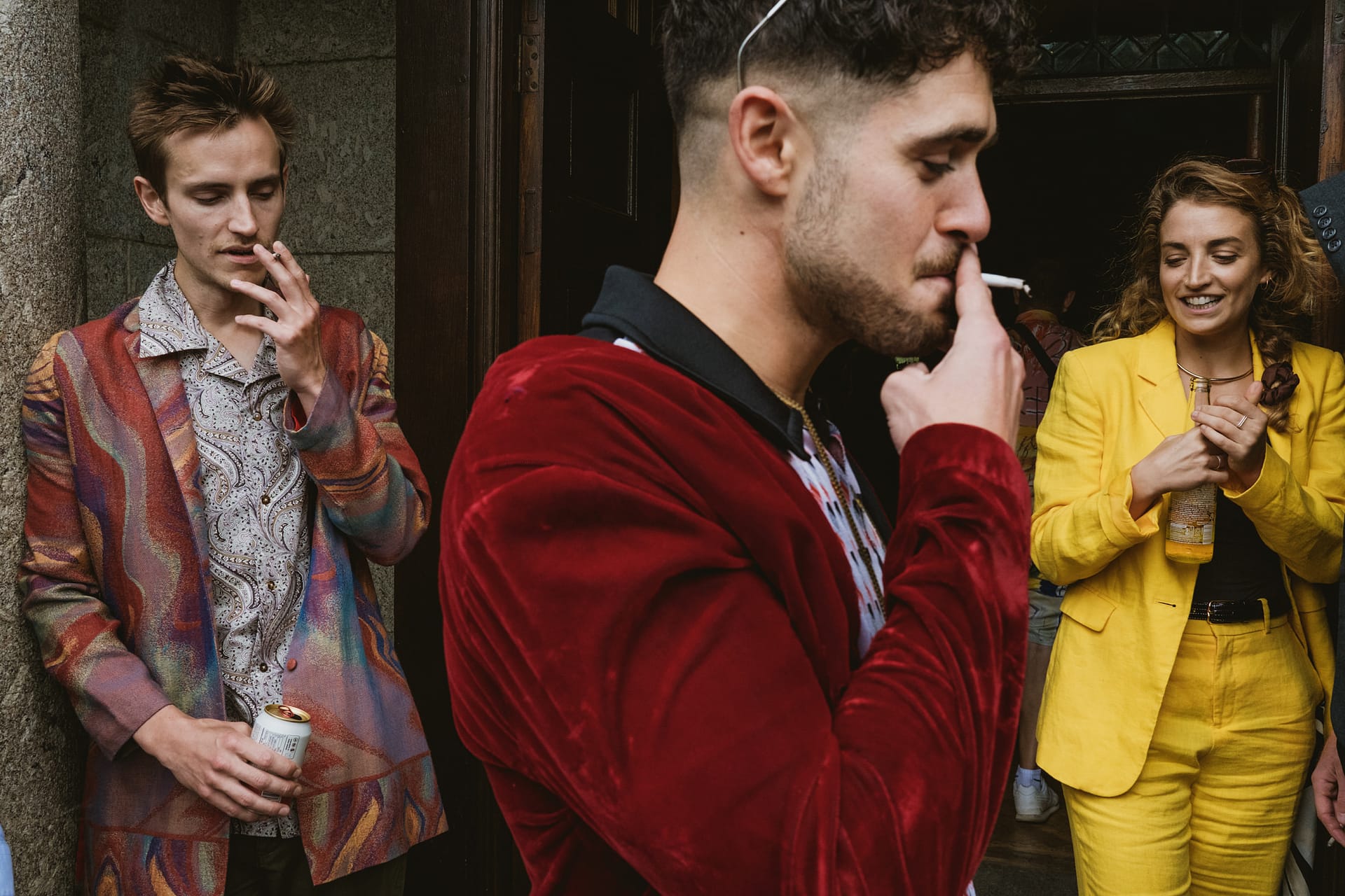 Three people in colourful suits, one smoking.