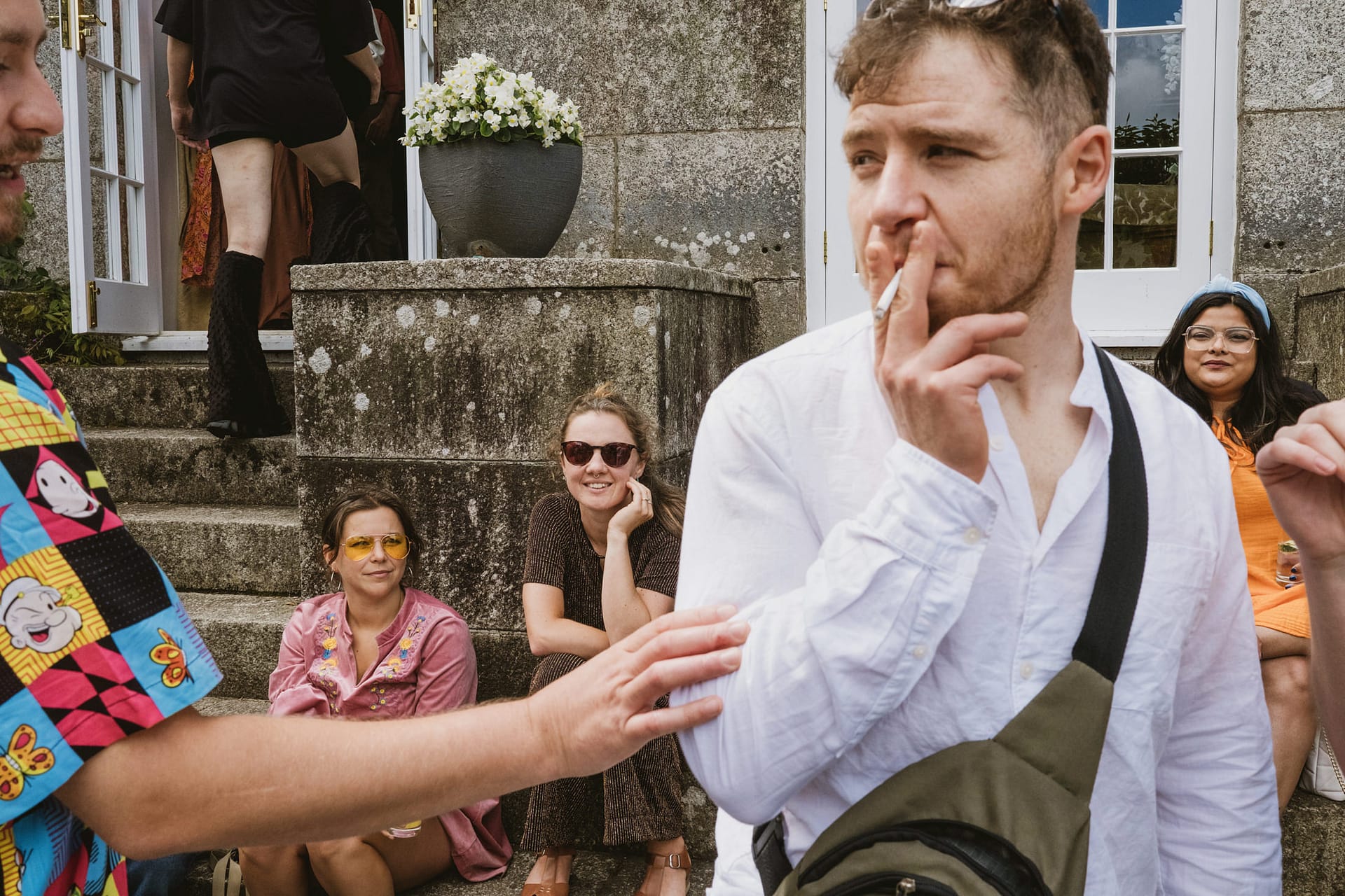 Group of friends outside house, one smoking