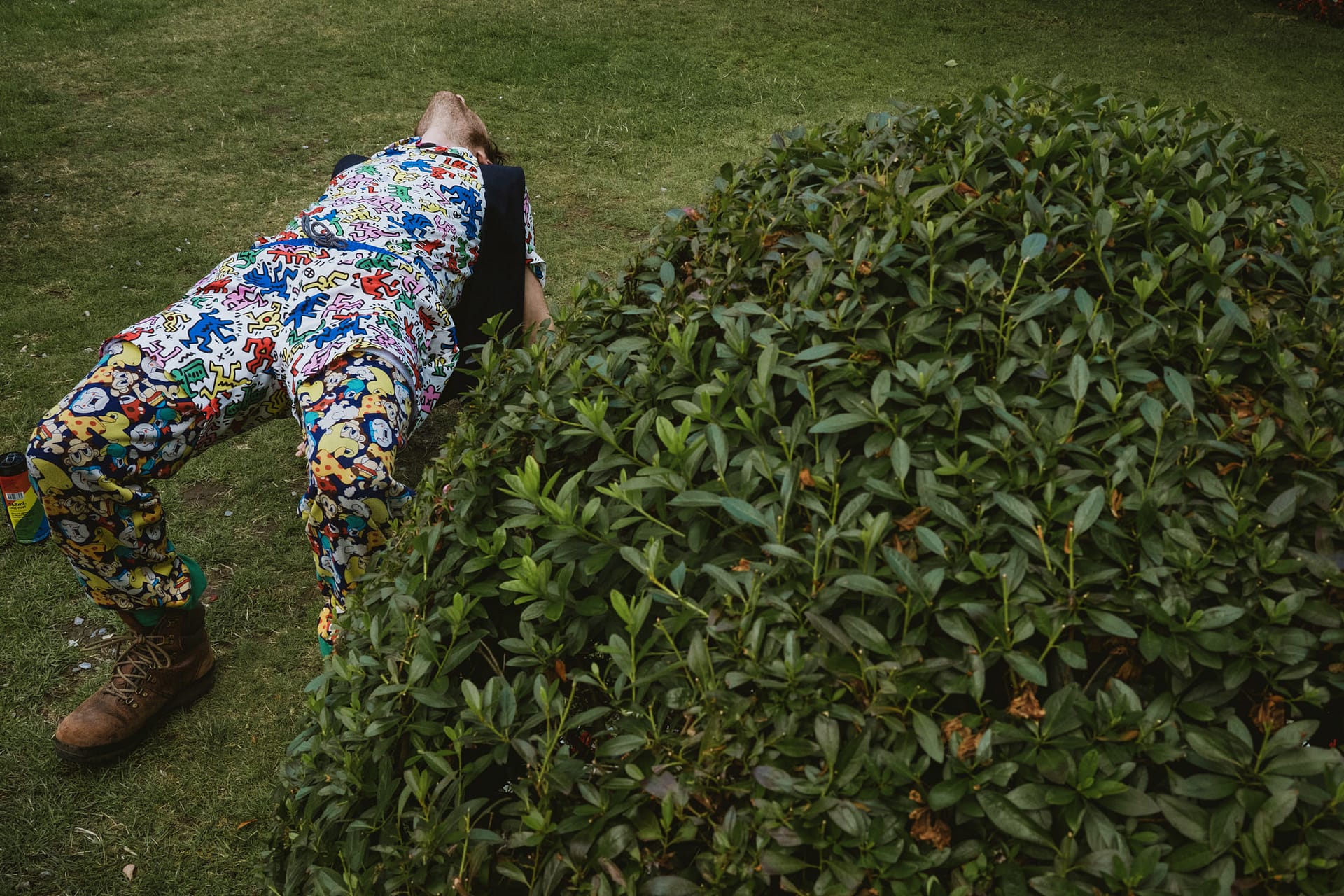 Person in colourful pyjamas lying on the grass.