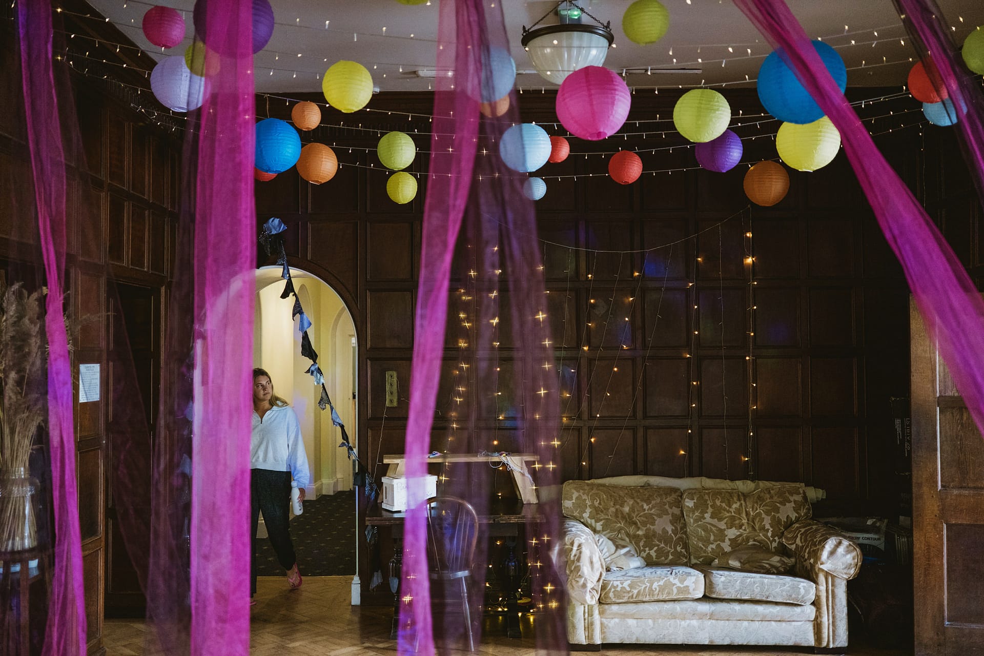 Colourful paper lanterns and fairy lights in decorated room.